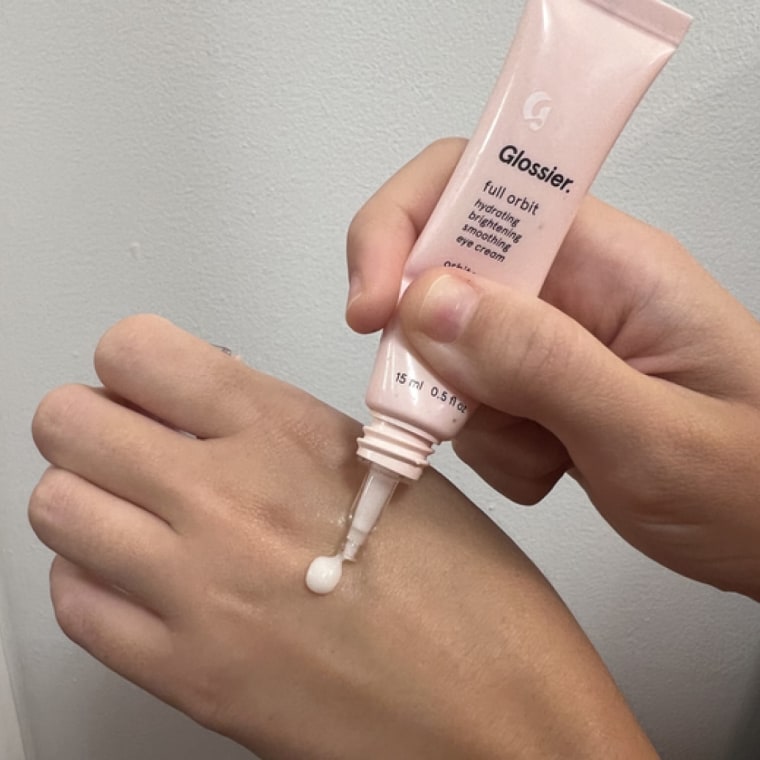 Woman dispenses Glossier Full Orbit onto her hand.