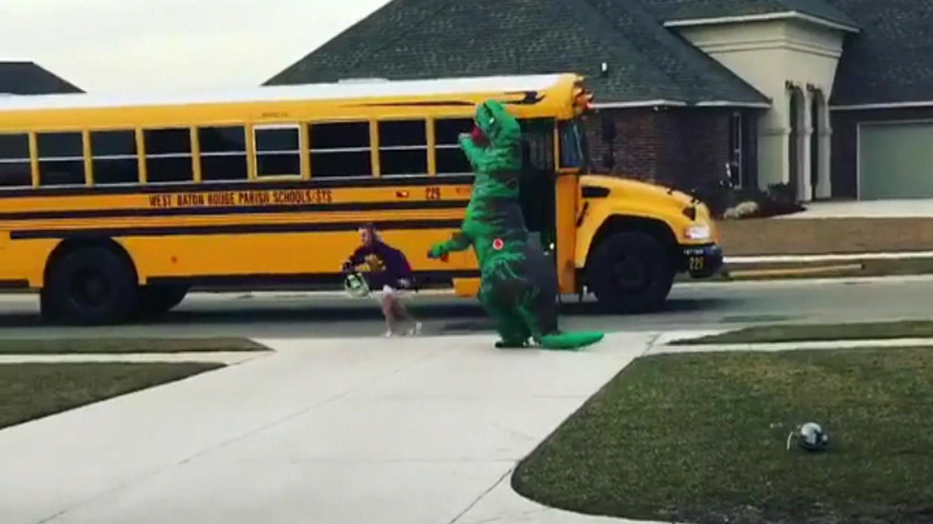 This cheerleader performing her routine in an inflatable dinosaur