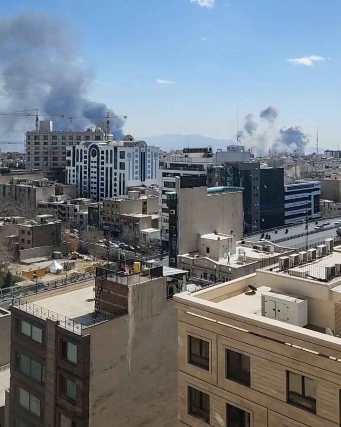 Smoke plumes above buildings in the distance