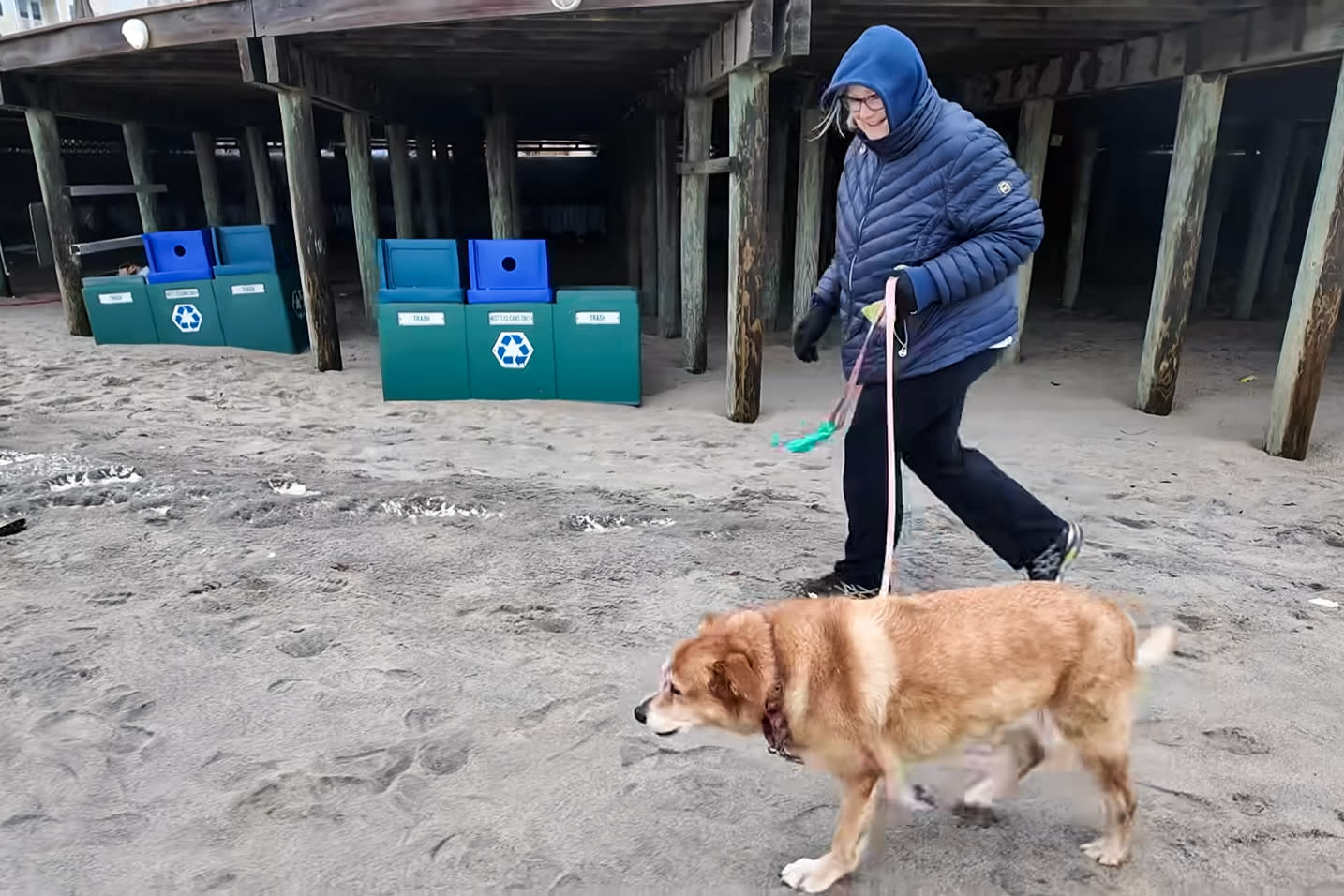 Kathryn South walks on the beach with her dog, Holly Golightly