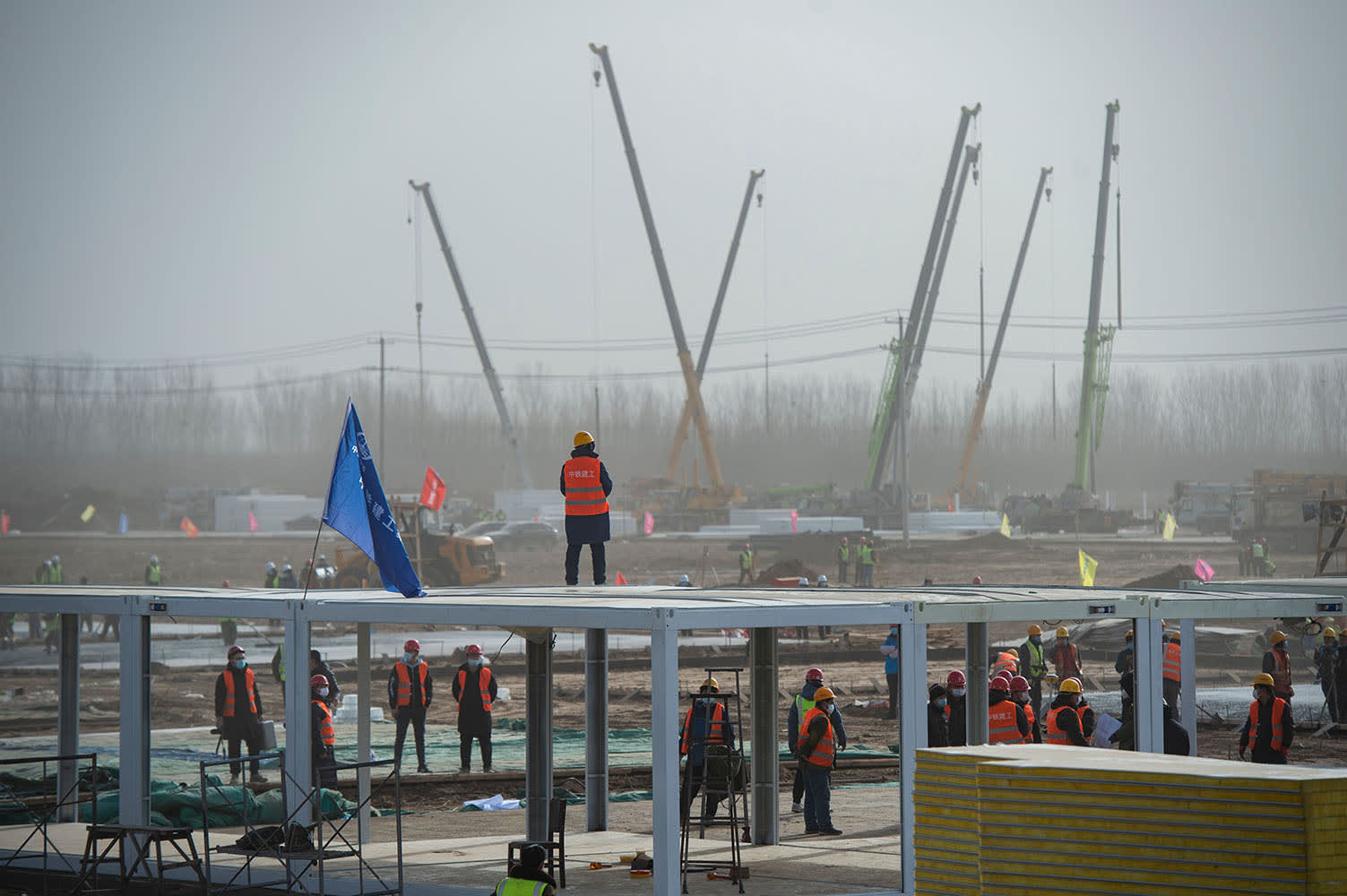 Image: Construction staff work at the construction site of the centralized medical observation center, a makeshift facility to isolate people at risk of contracting the Covid-19 coronavirus in Shijiazhuang, in northern China's Hebei province
