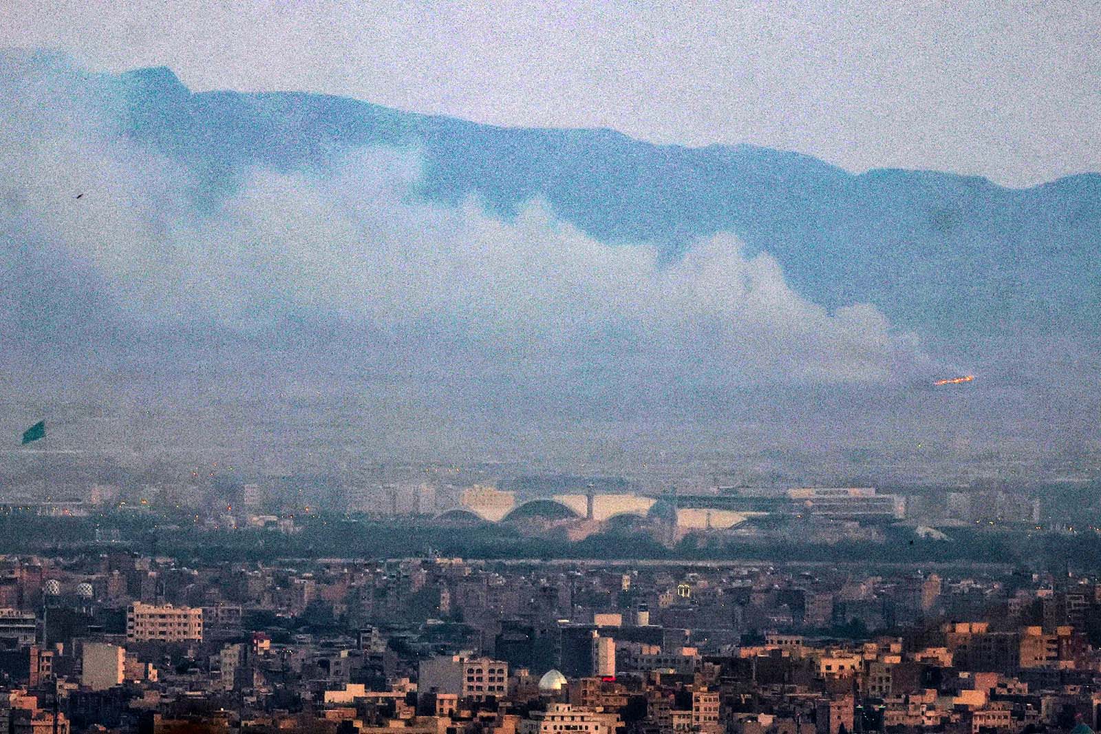 Smoke and fire billow from the site of an alleged Israeli strike in southern Tehran