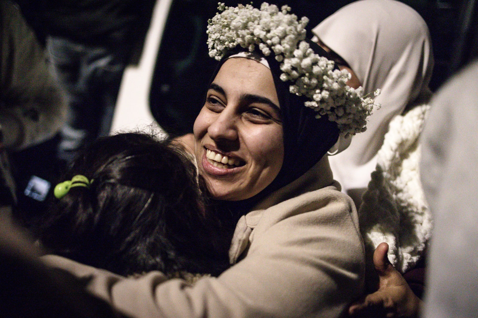 A woman wearing a flower crown is embraced