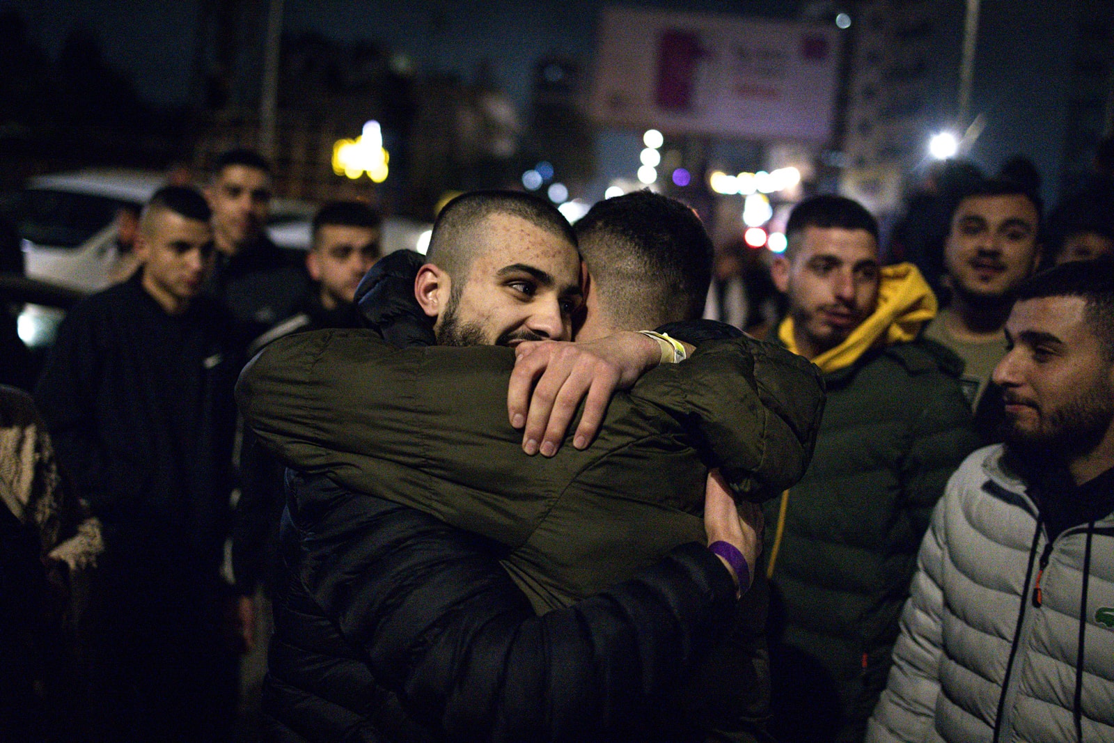 People embrace in a crowd outside