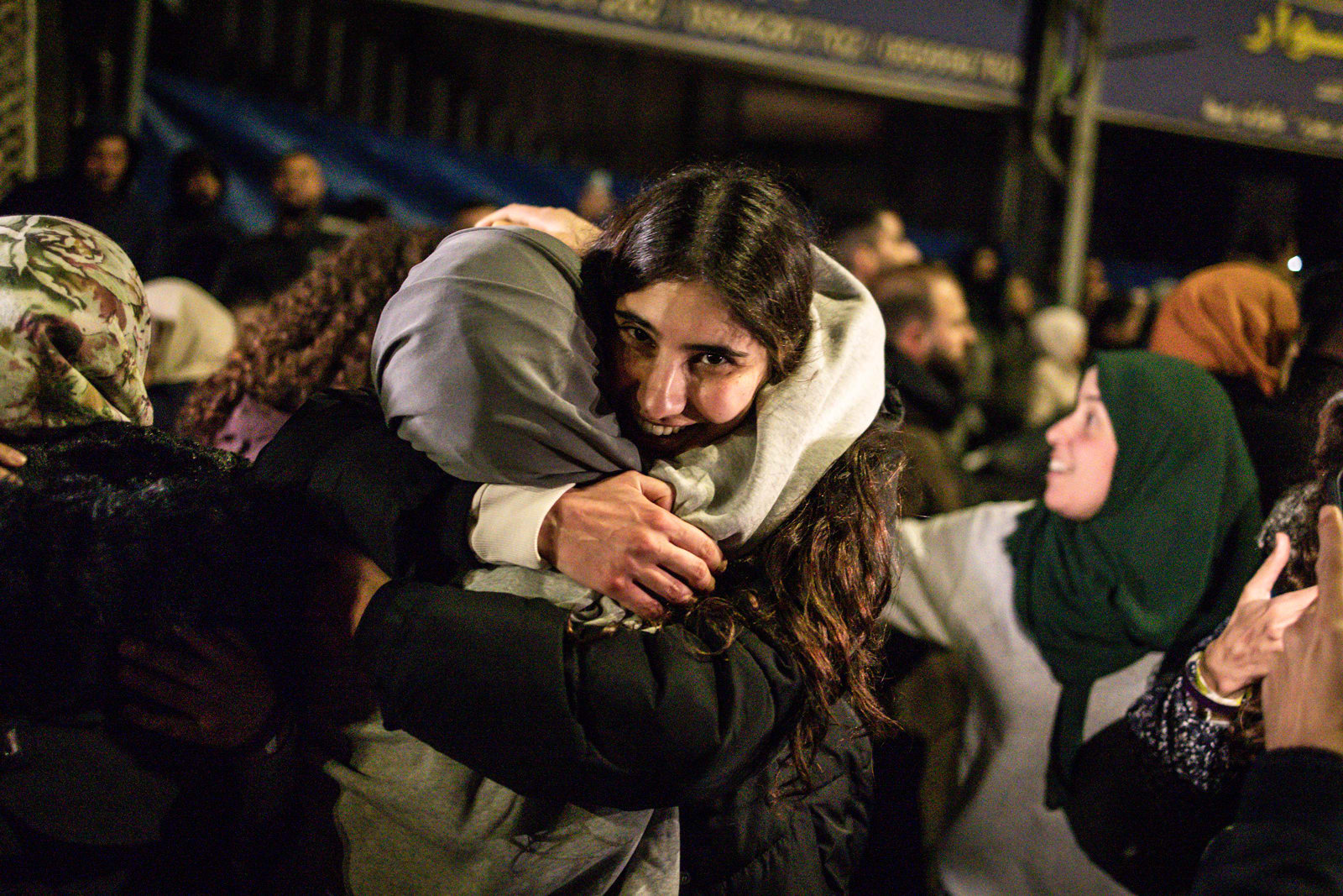 People embrace in a crowd outside