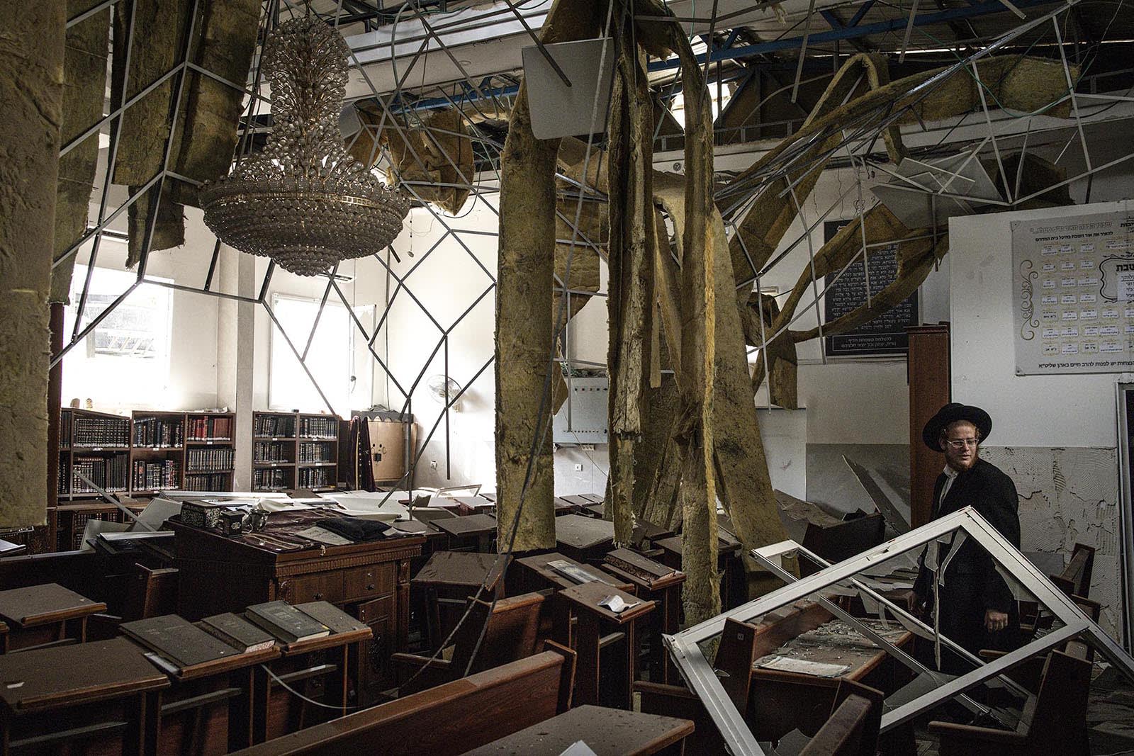 An Ultra-Orthodox Jewish man inspects the damage inside a synagogue at the site of an Iranian missile strike in Bnei Brak, east of Tel Aviv, on June 16, 2025. 