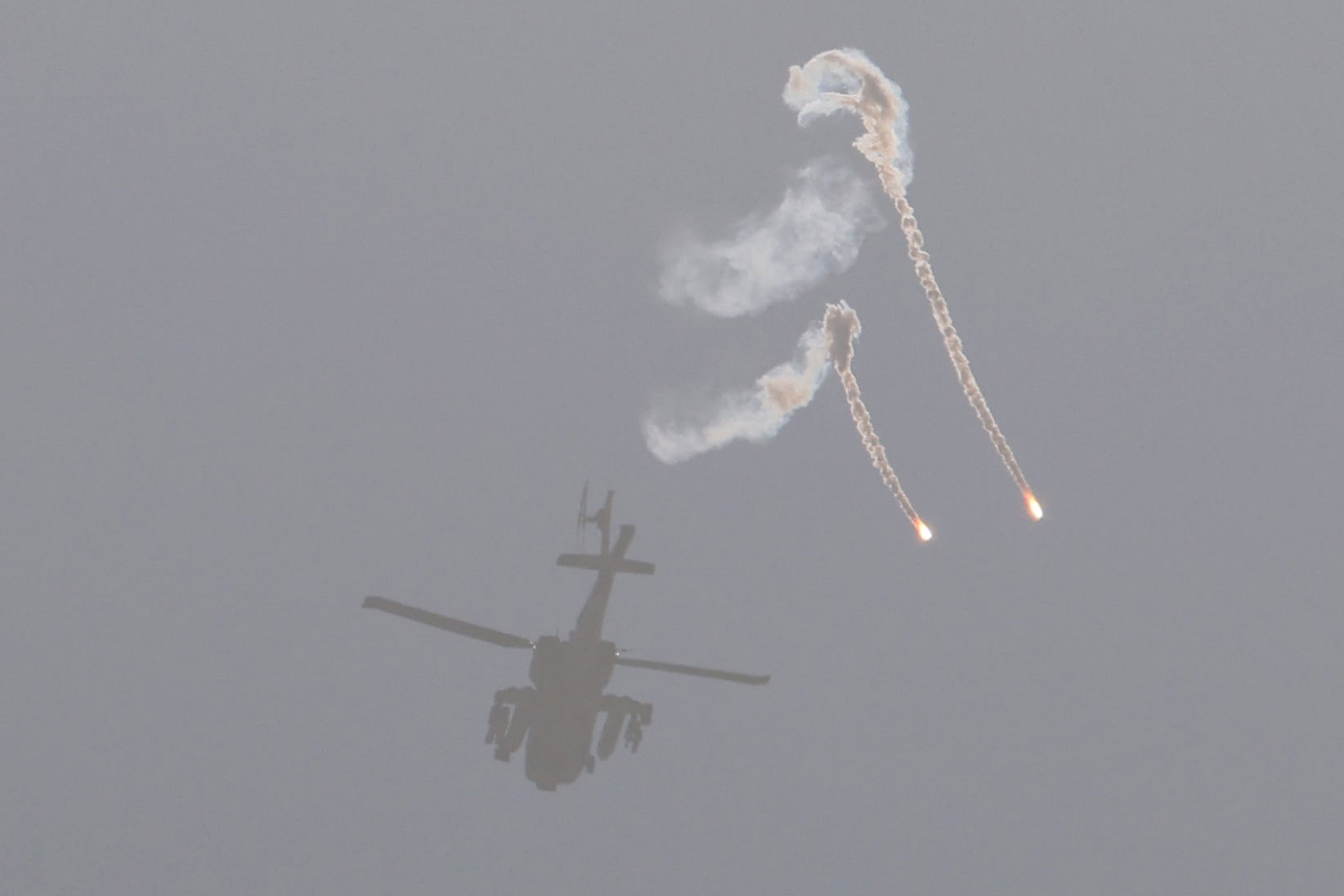 An Israeli air force attack helicopter releases flares while flying over the border with the Gaza Strip on Dec. 1, 2023.