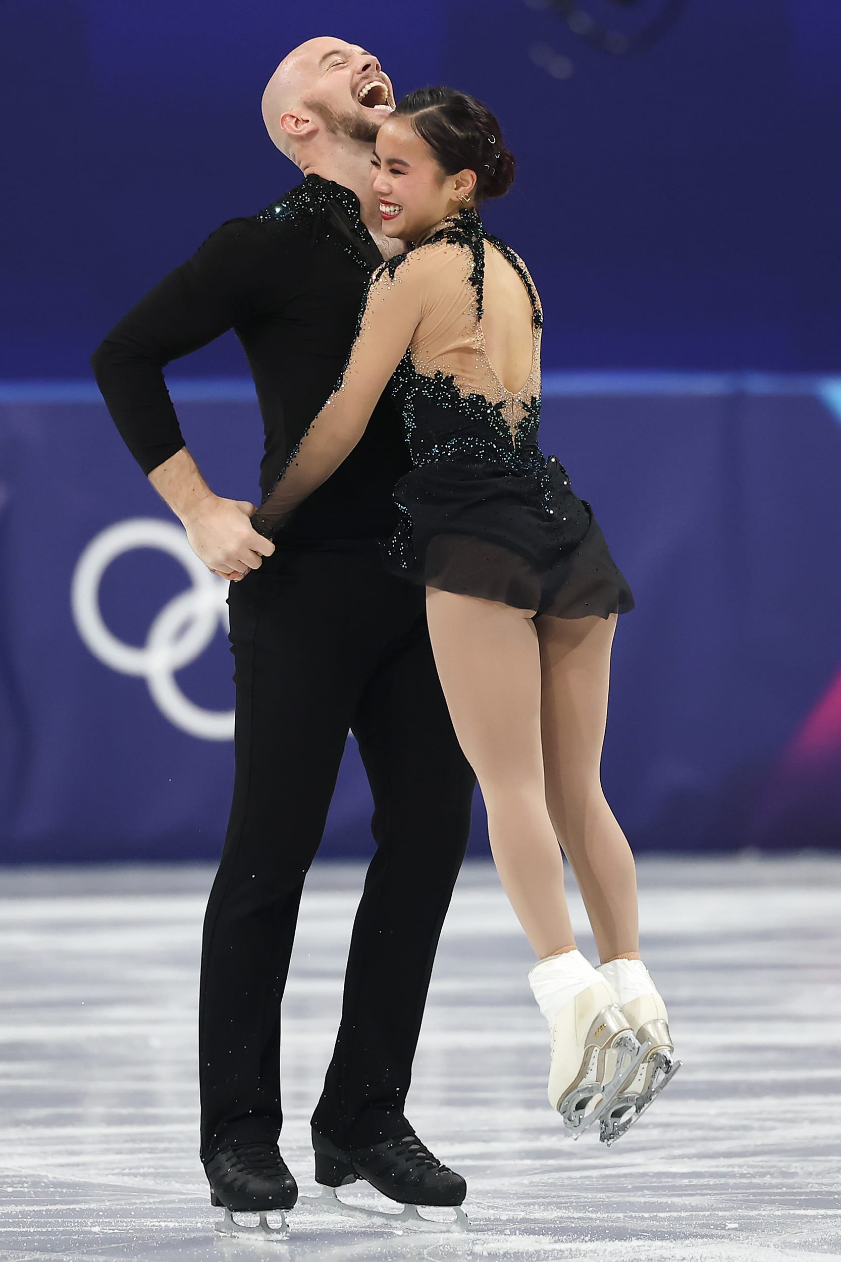 Ellie Kam and Danny O’Shea embrace with wide grins while celebrating on the ice.
