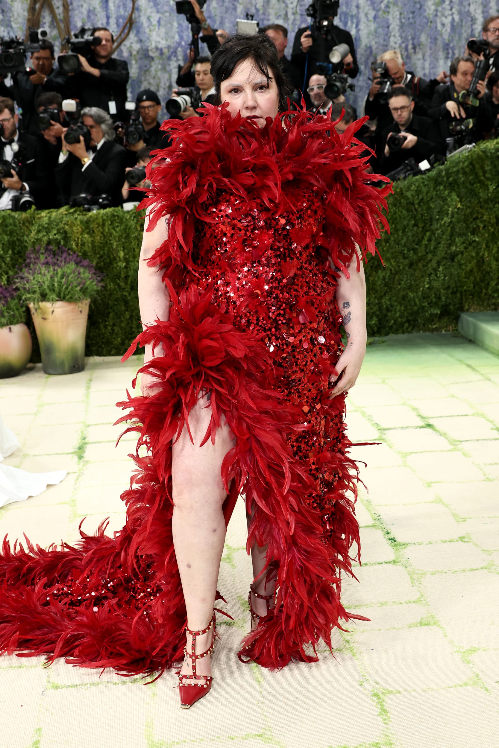Lena Dunham in a red feathered dress.