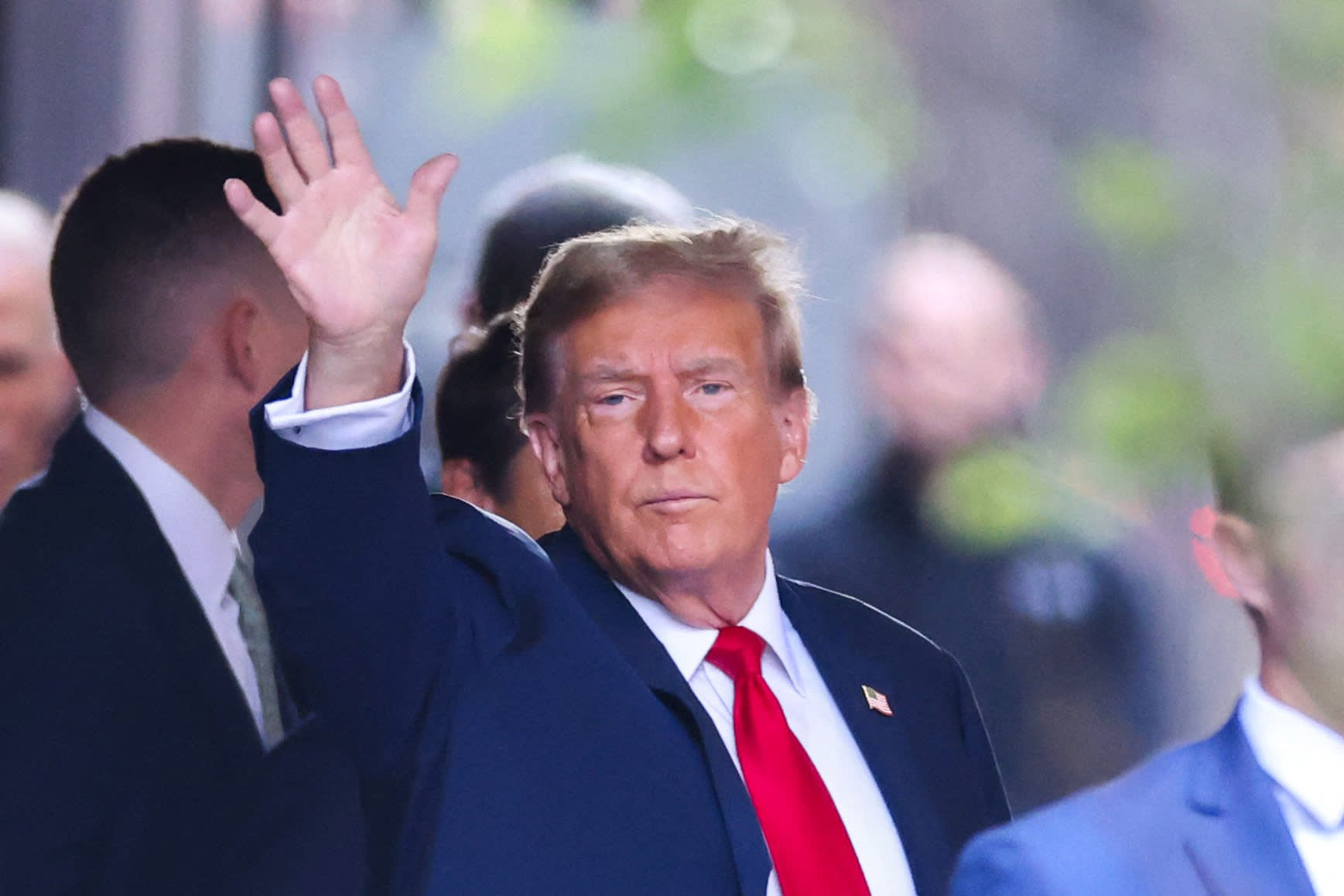 Former President Donald Trump waves as he departs Trump Tower for Manhattan Criminal Court on April 15, 2024.