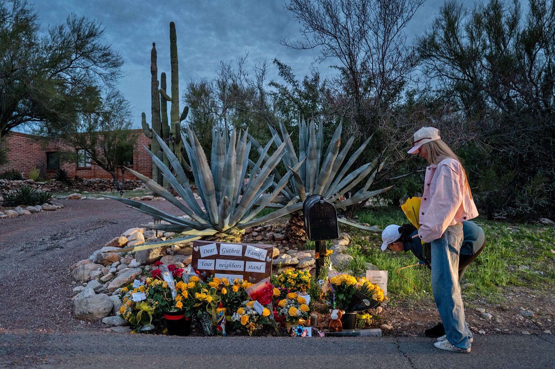 People stop at a makeshift memorial at the entrance to Nancy Guthrie's home on Feb. 12, 2026 in Tucson, Ariz.