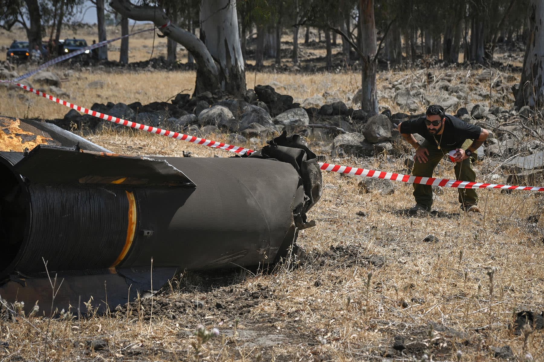 Members of the Israeli security forces check the apparent remains of an Iranian ballistic missile