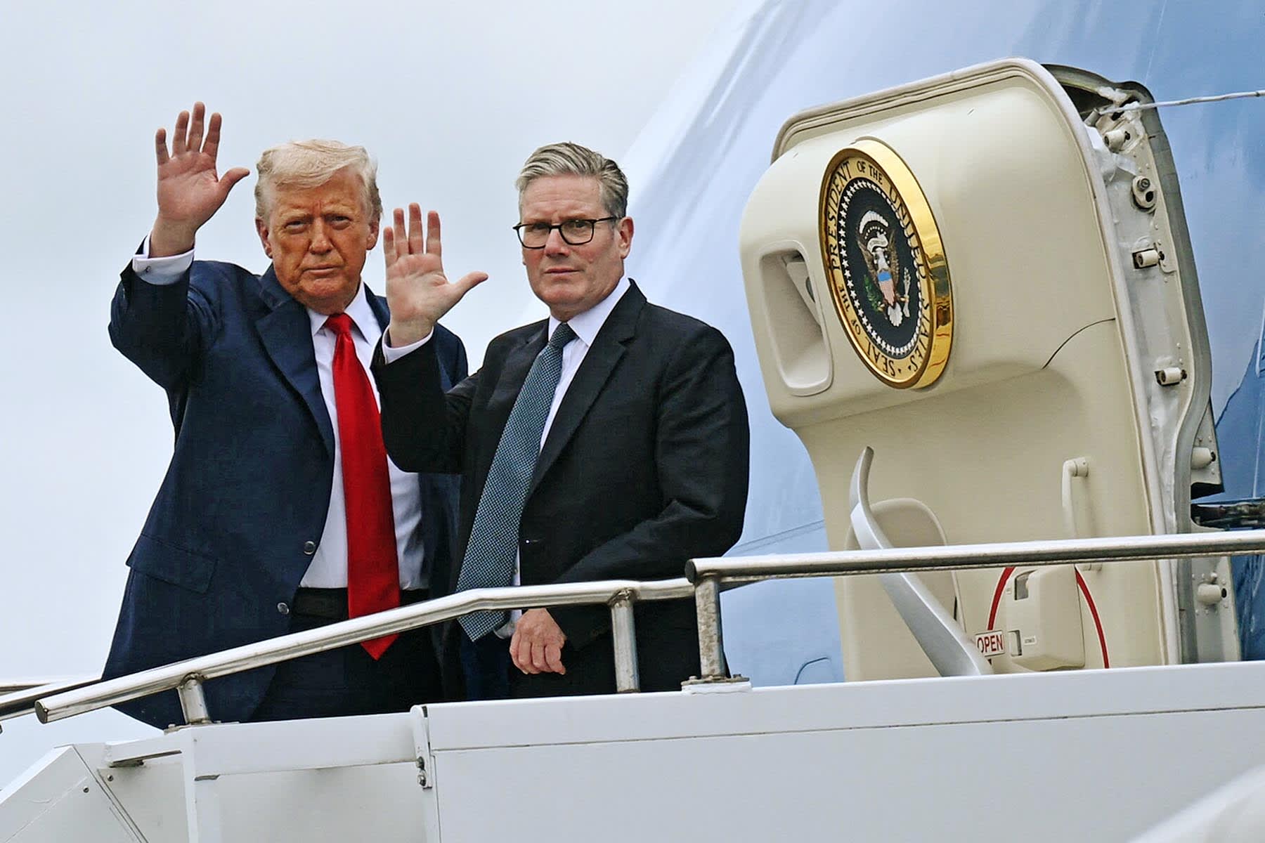 President Donald Trump and Britain's Prime Minister Keir Starmer wave as they board Air Force One in Glasgow, Scotland on July 28, 2025.