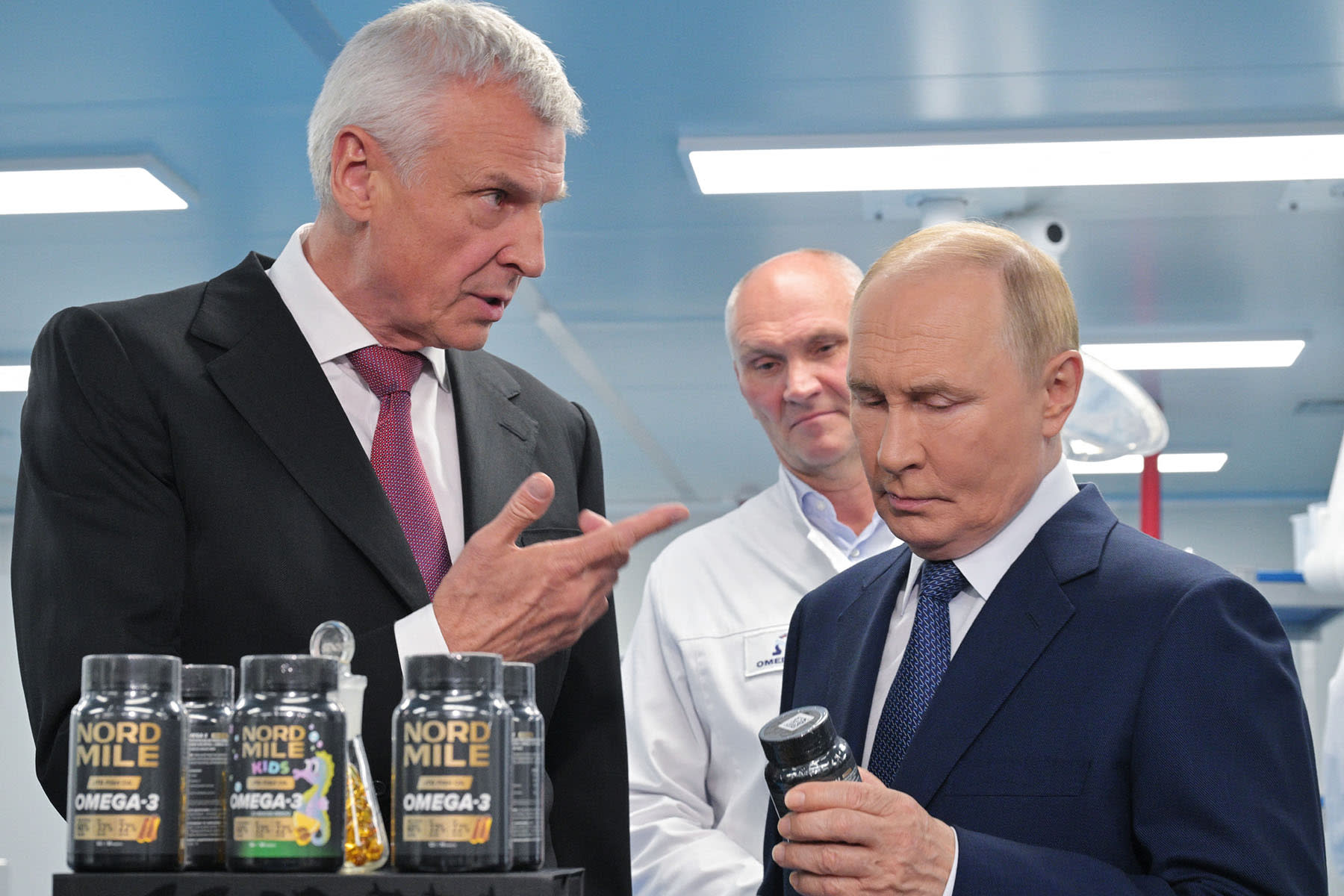 Russia's President Vladimir Putin looks at a jar of omega-3 pills CONFLICT