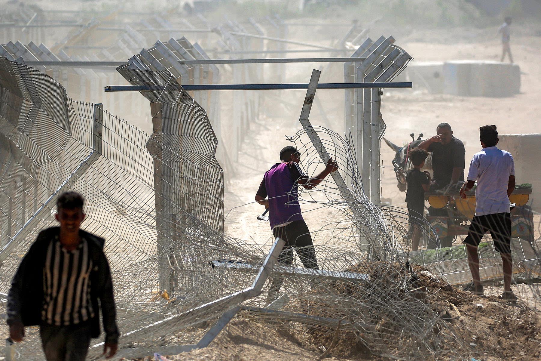 A man attempts to remove the fence and barriers at the so-called "Netzarim corridor" near Nuseirat in the central Gaza Strip on Oct. 10, 2025, as people make their way back to Gaza City.