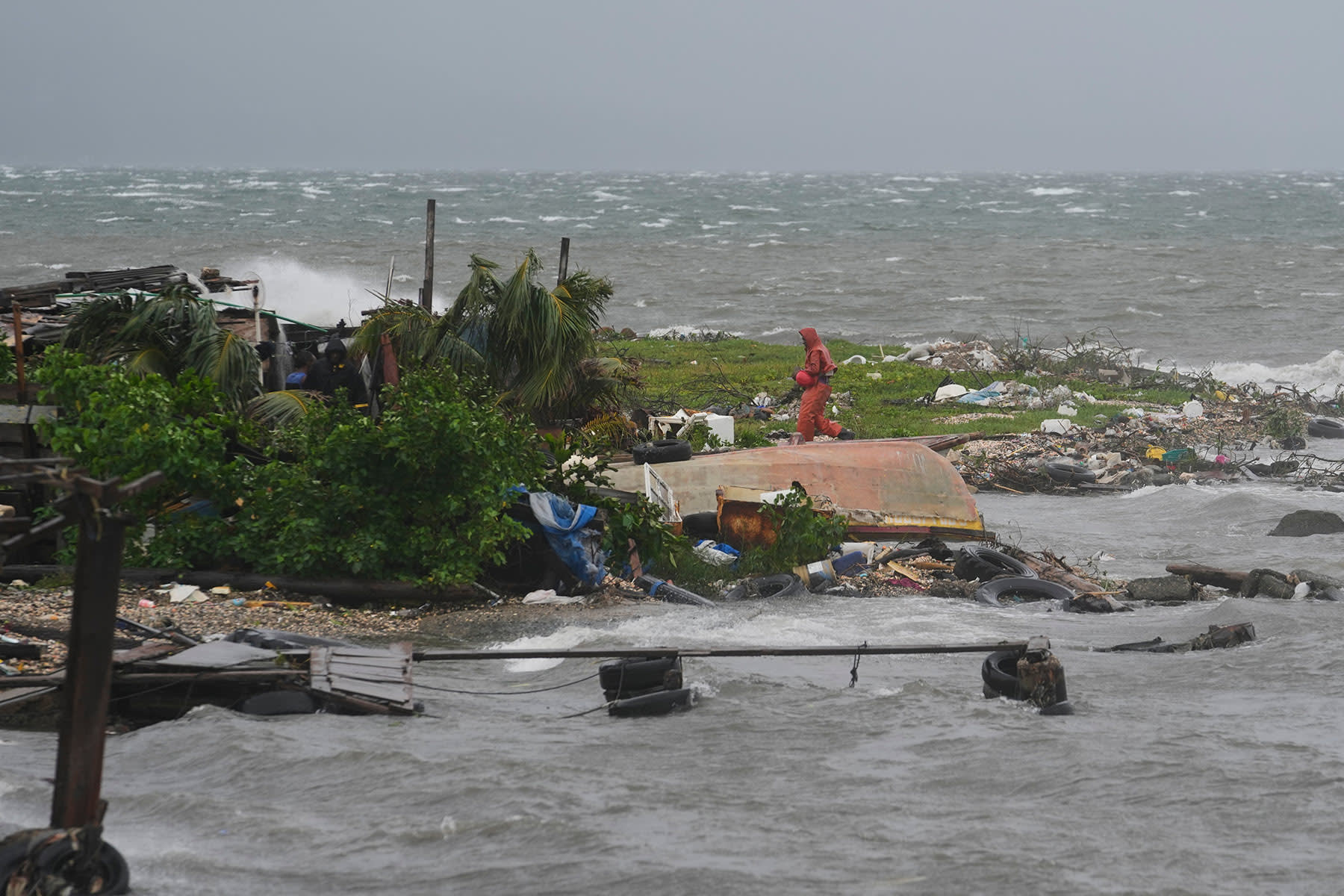 A man walks along the coastline in Kingston, Jamaica, as Hurricane Melissa approaches, Tuesday, Oct. 28, 2025. 