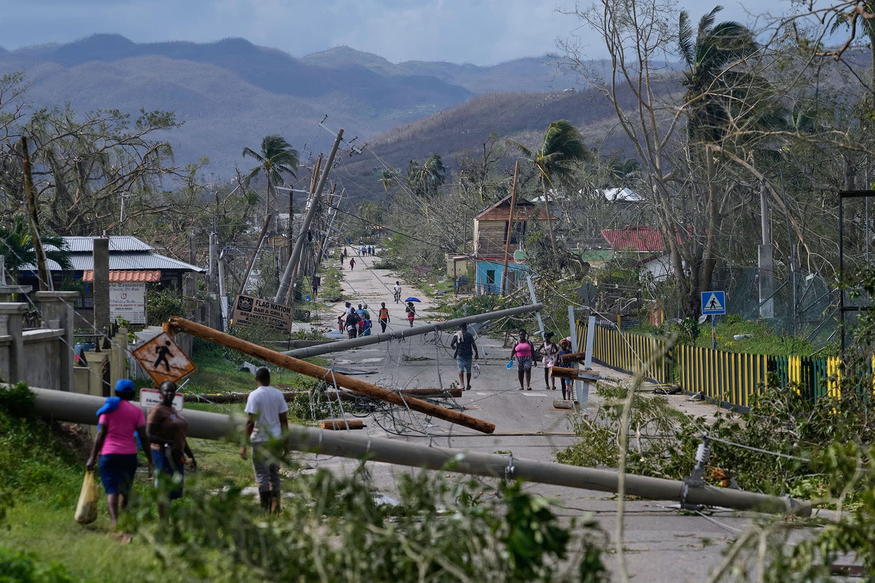 Residents walk through Lacovia Tombstone, Jamaica, in the aftermath of Hurricane Melissa, Wednesday, Oct. 29, 2025.