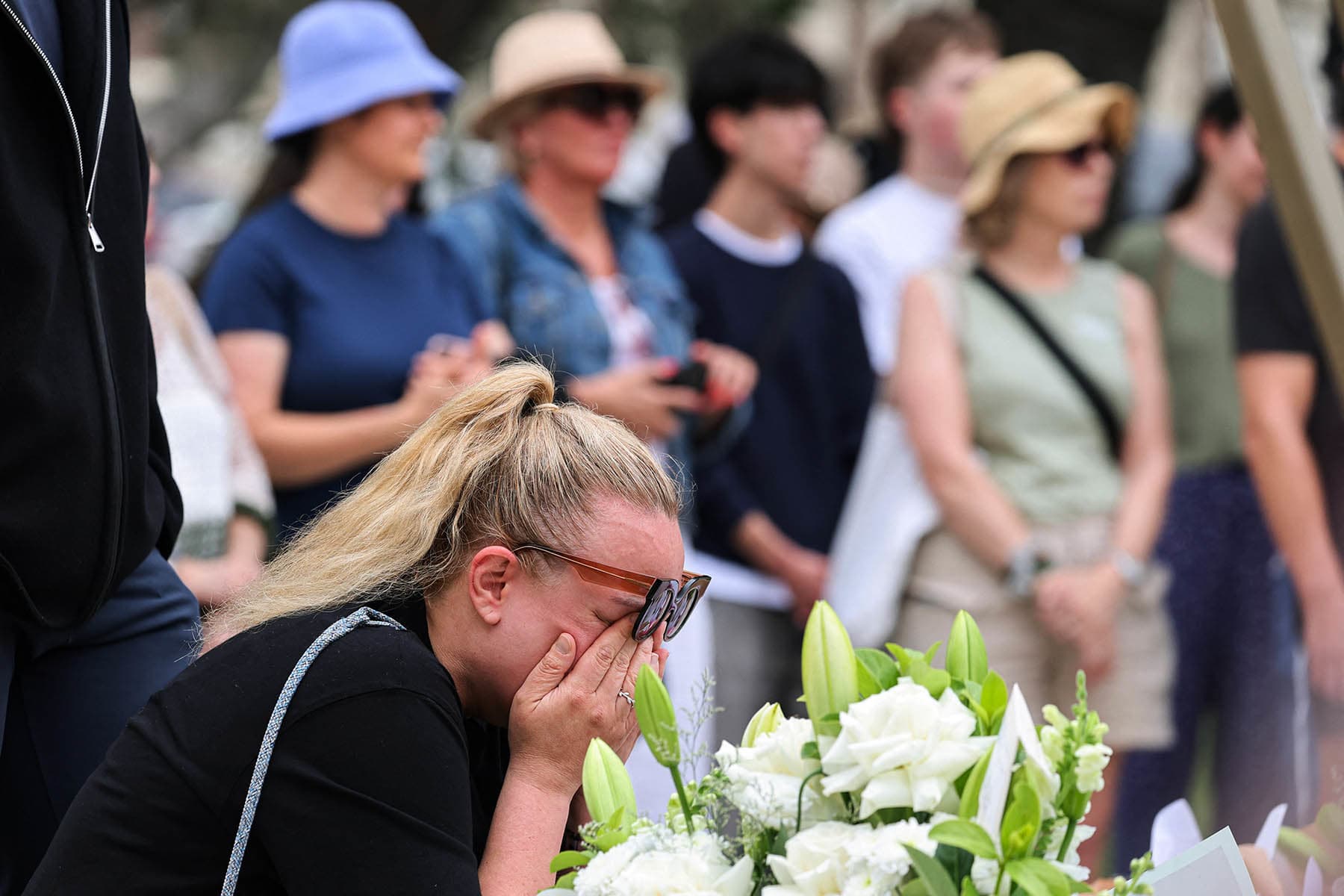 A woman weeps after laying flowers outside Bondi Pavilion in Sydney on Dec. 16, 2025, to honor victims of the Bondi Beach shooting. 