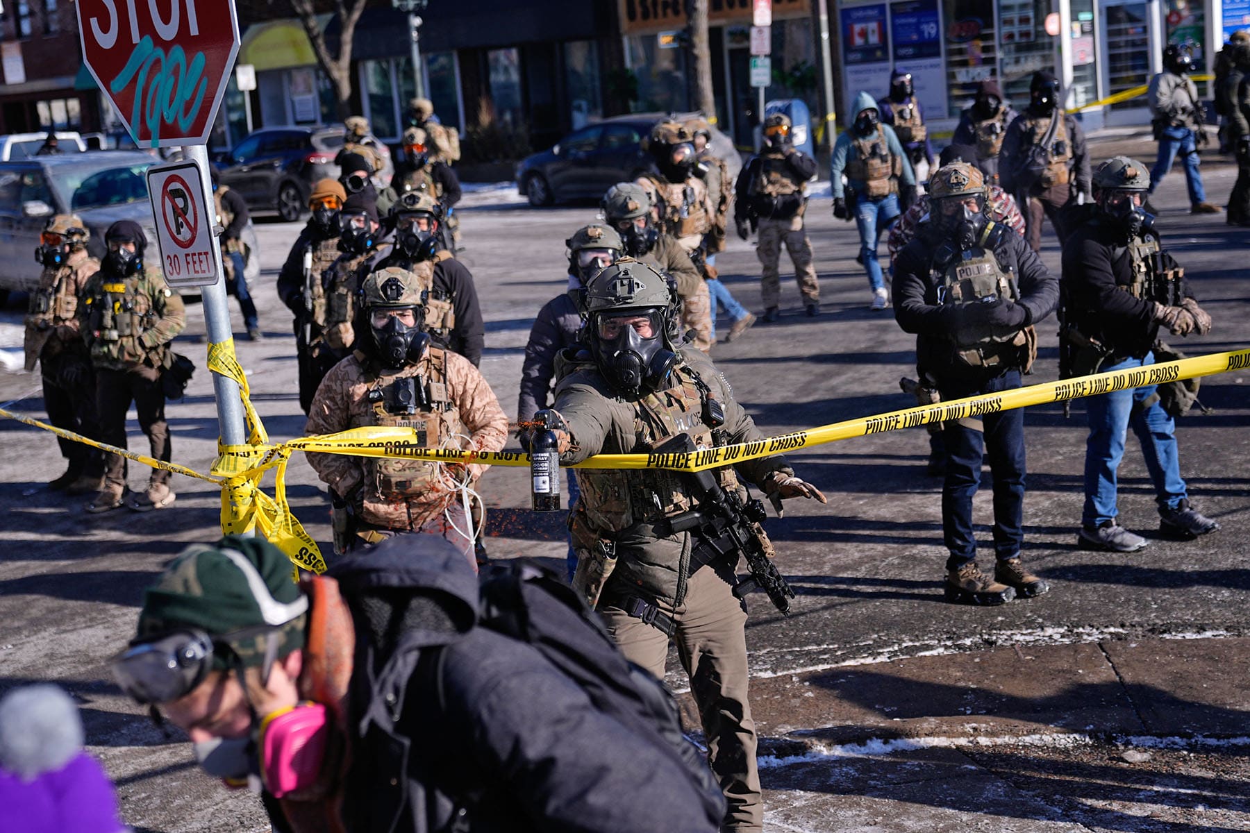 Federal immigration officers deploy pepper spray at observers after a shooting Saturday, Jan. 24, 2026, in Minneapolis. 