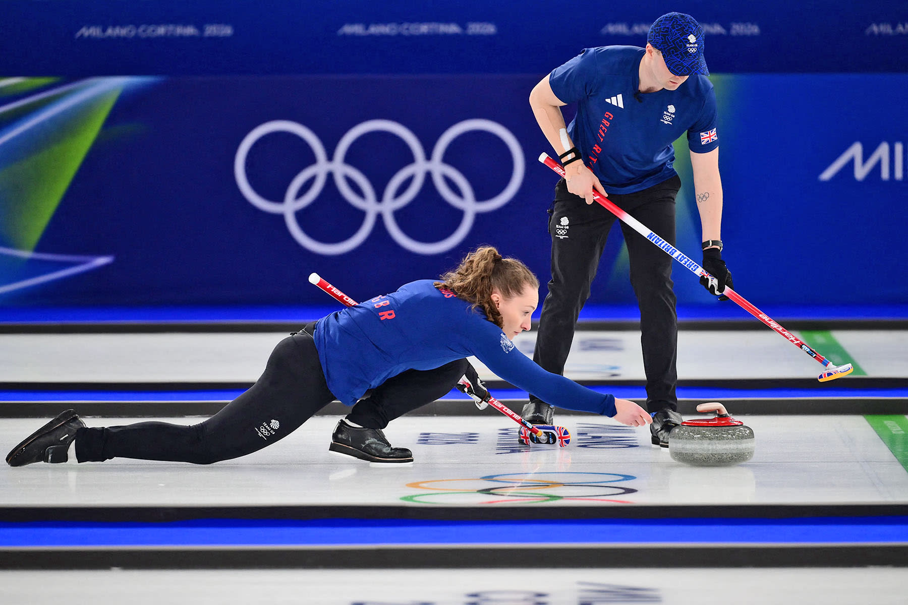 Britain's Jennifer Dodds curls the stone past Britain's Bruce Mouat 
