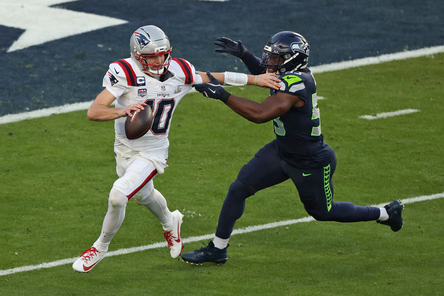 Seattle Seahawks' linebacker #53 Boye Mafe attempts to block New England Patriots' quarterback #10 Drake Maye