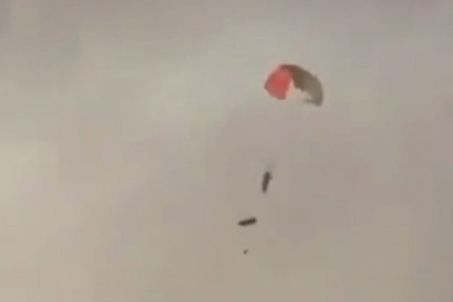 A pilot descends from the sky with a parachute near al-Jahra in Kuwait after three U.S. warplanes were mistakenly shot down