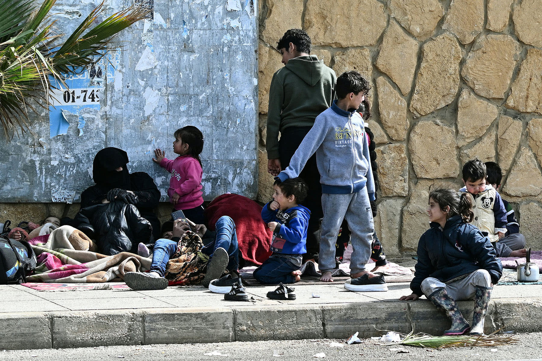 Residents who fled Israeli airstrikes in Beirut's southern suburbs sit along the corniche waterfront in the Lebanese capital on March 6, 2026.