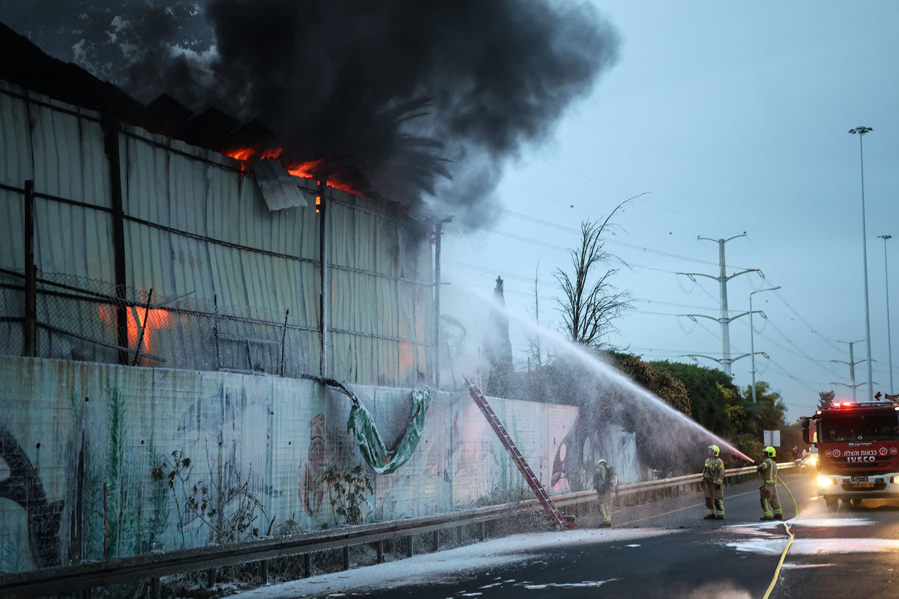 Firefighters extinguish a fire at the site of a strike on the outskirts of Tel Aviv on March 13, 2026. 