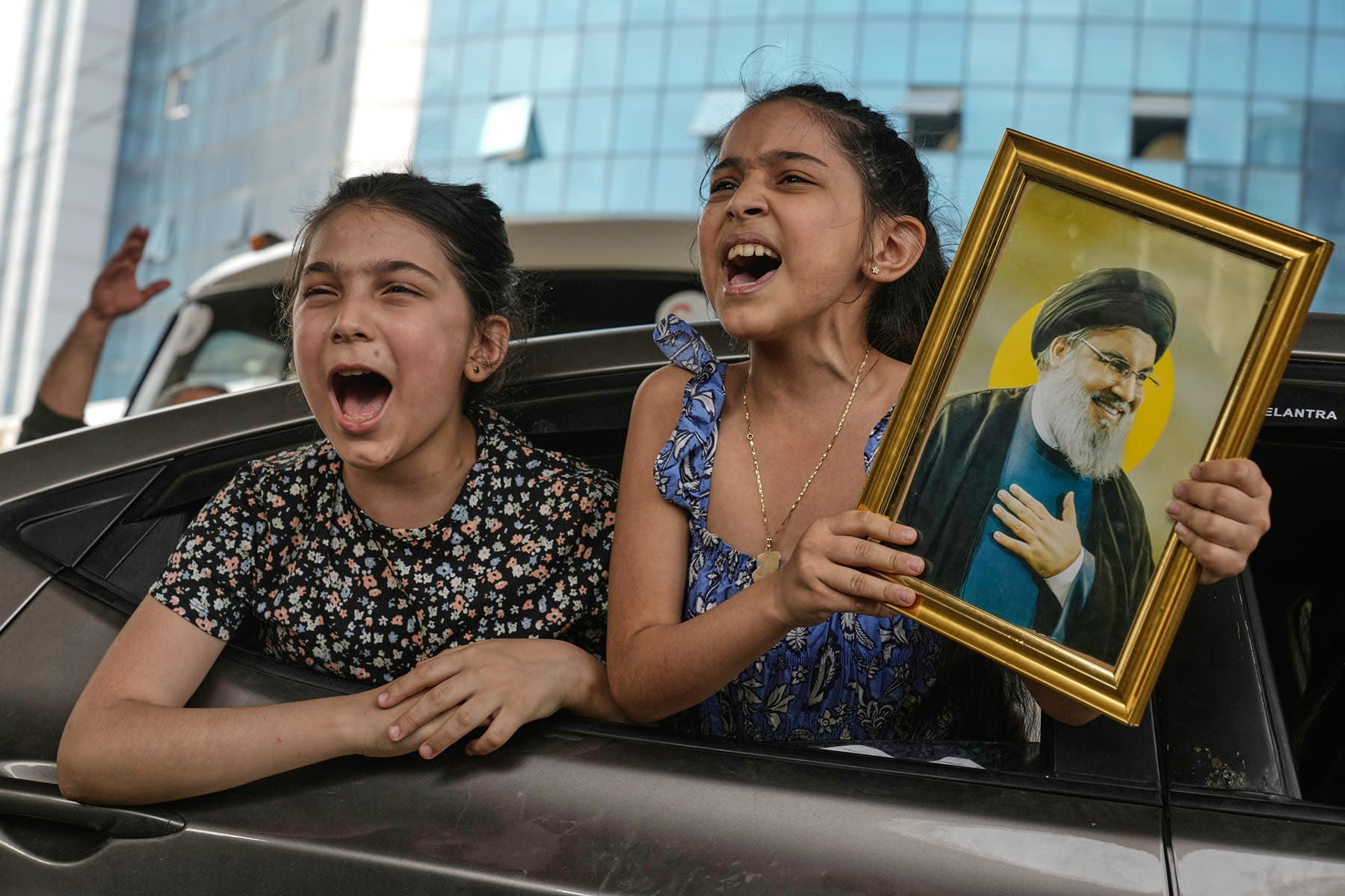 A girl holds an image of the late Hezbollah leader Hassan Nasrallah 