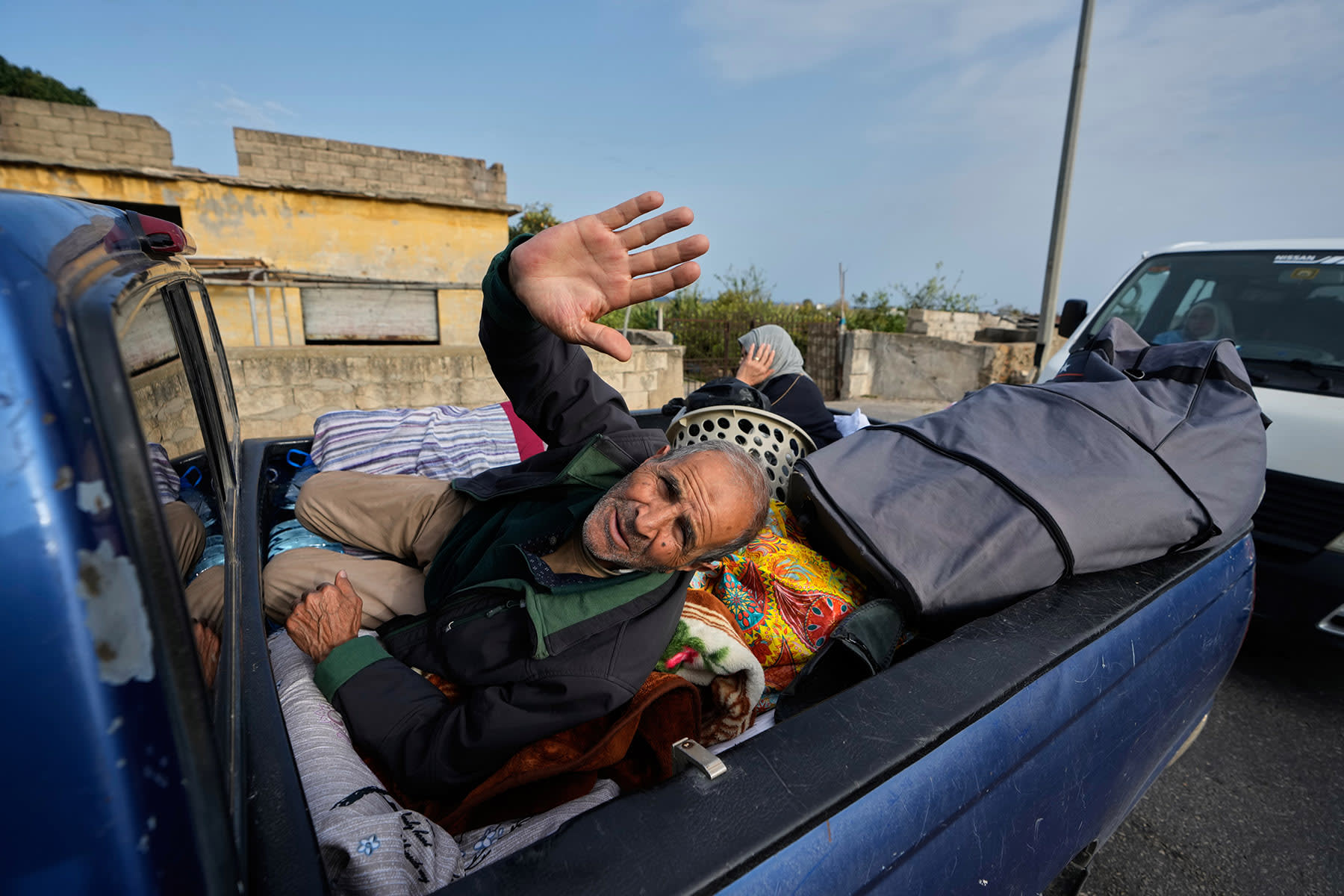 A displaced man waves in Qasmiyeh, near Tyre in southern Lebanon