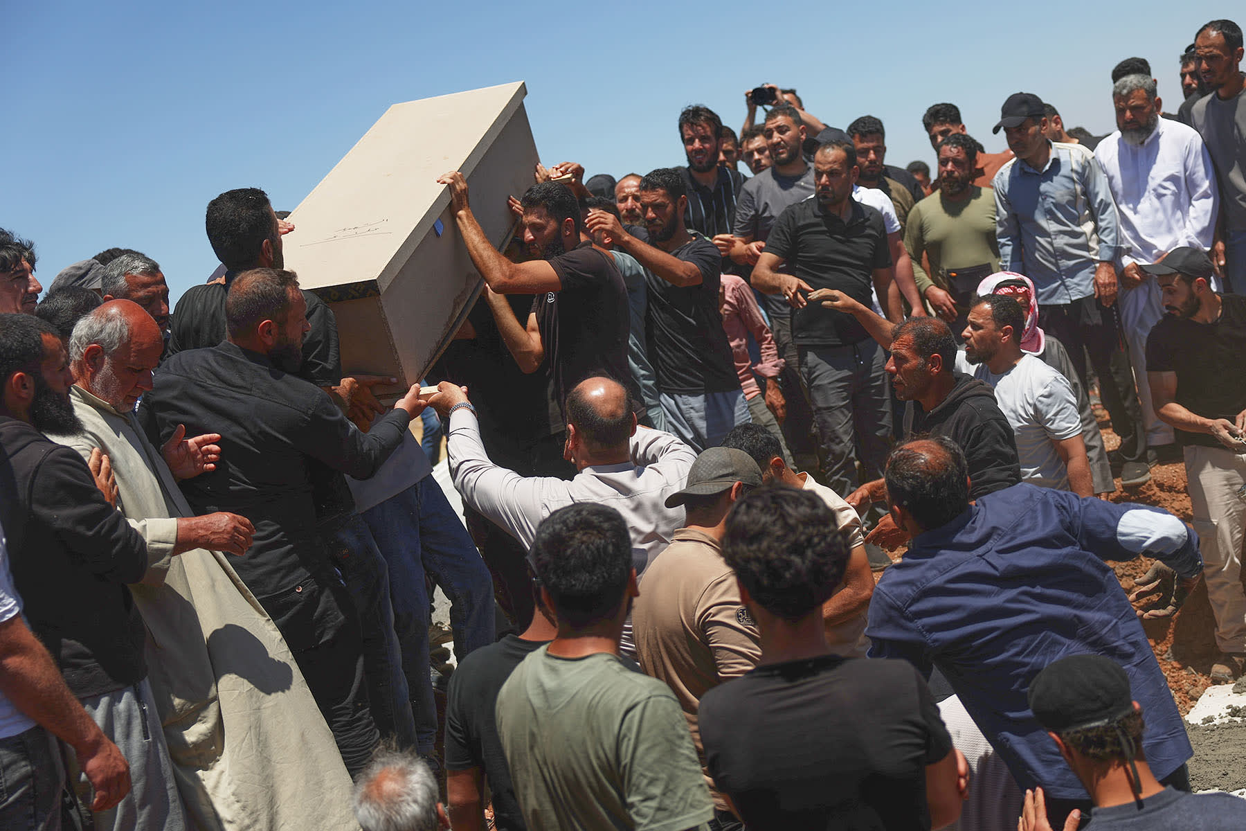 Mourners carry one of the four coffins of members of the al-Hariri family, killed in Israeli strikes