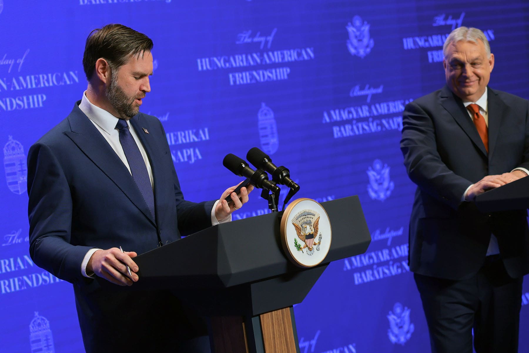 Vice President JD Vance looks at his phone and comments about an unread message from U.S. Special Envoy Steve Witkoff at a news conference with Hungarian Prime Minister Viktor Orban on April 7, 2026 in Budapest, Hungary.