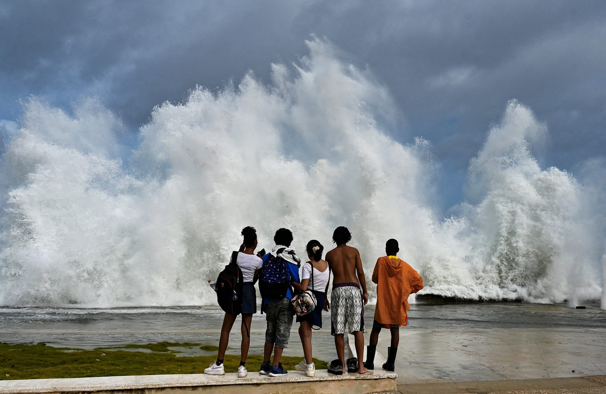 Young people look at waves crashing against the Malecon promenade in Havana due to the passage of Hurricane Milton on October 9, 2024.