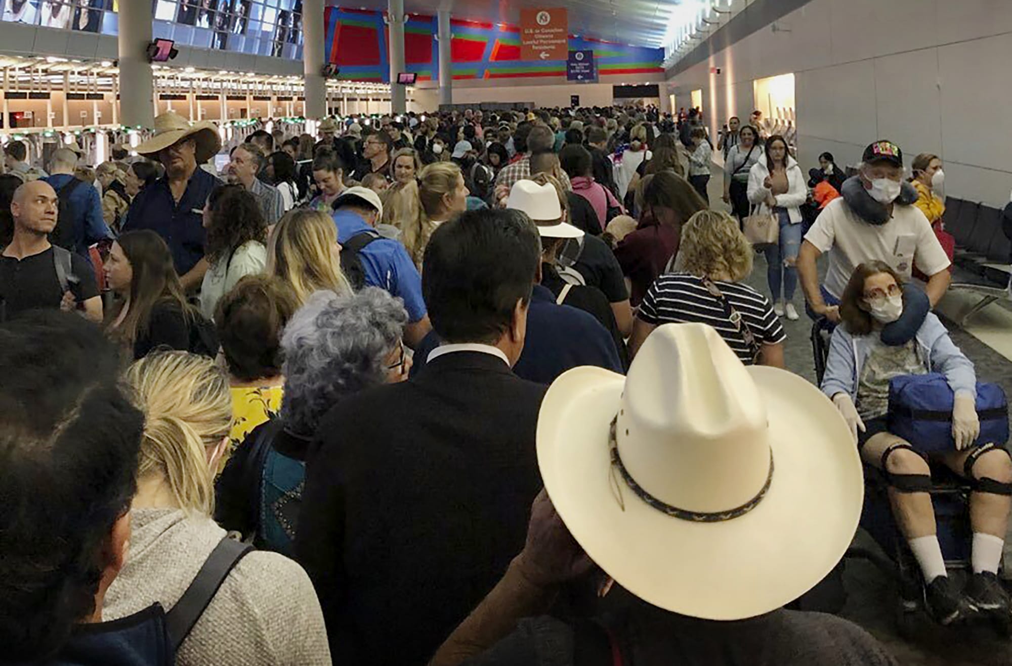 Image: People wait in line to go through customs at Dallas Fort Worth International Airport in Grapevine, Texas, on March 14, 2020.