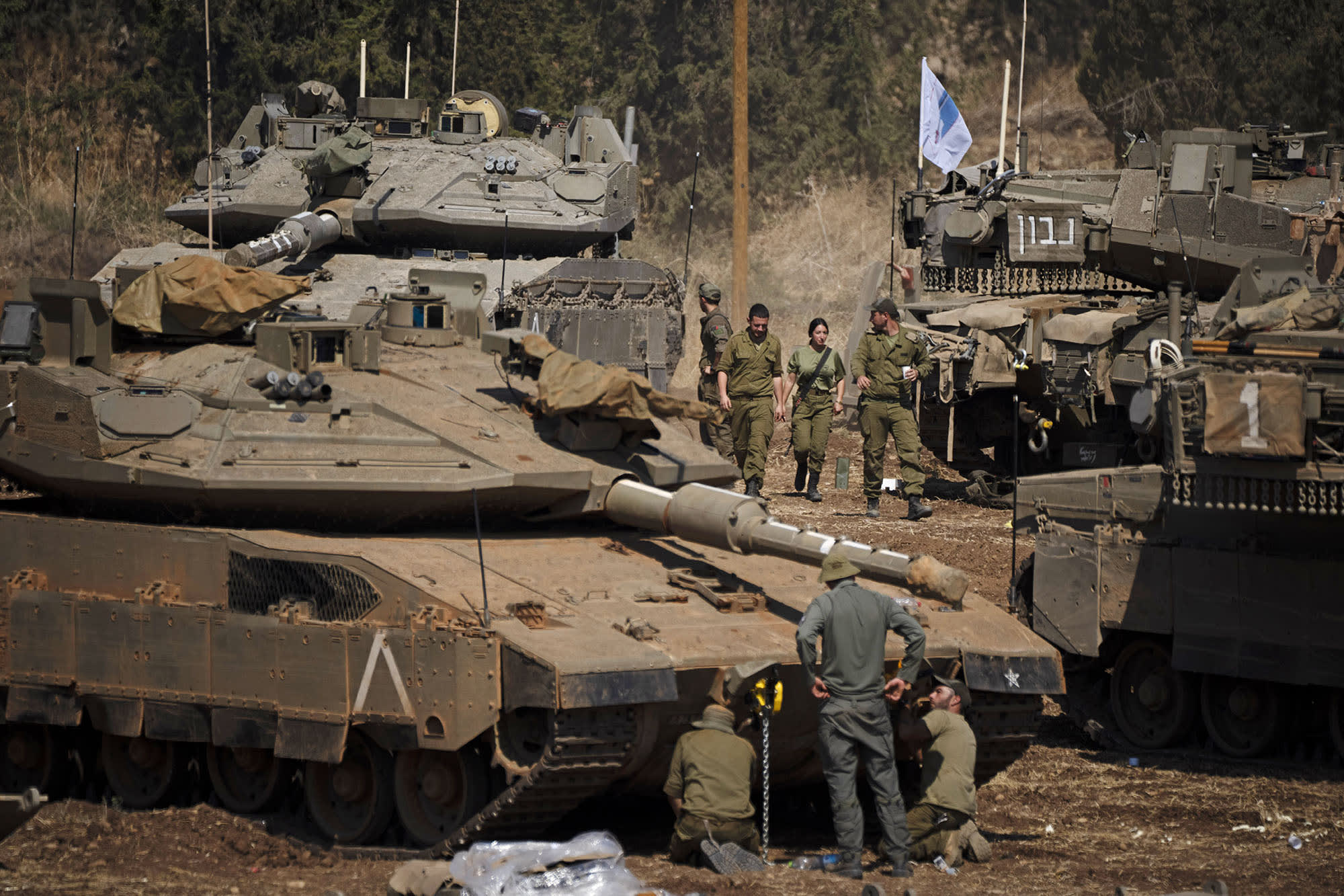 Israeli soldiers work on tanks and armored personnel carriers in northern Israel, Monday, Sept. 30, 2024.