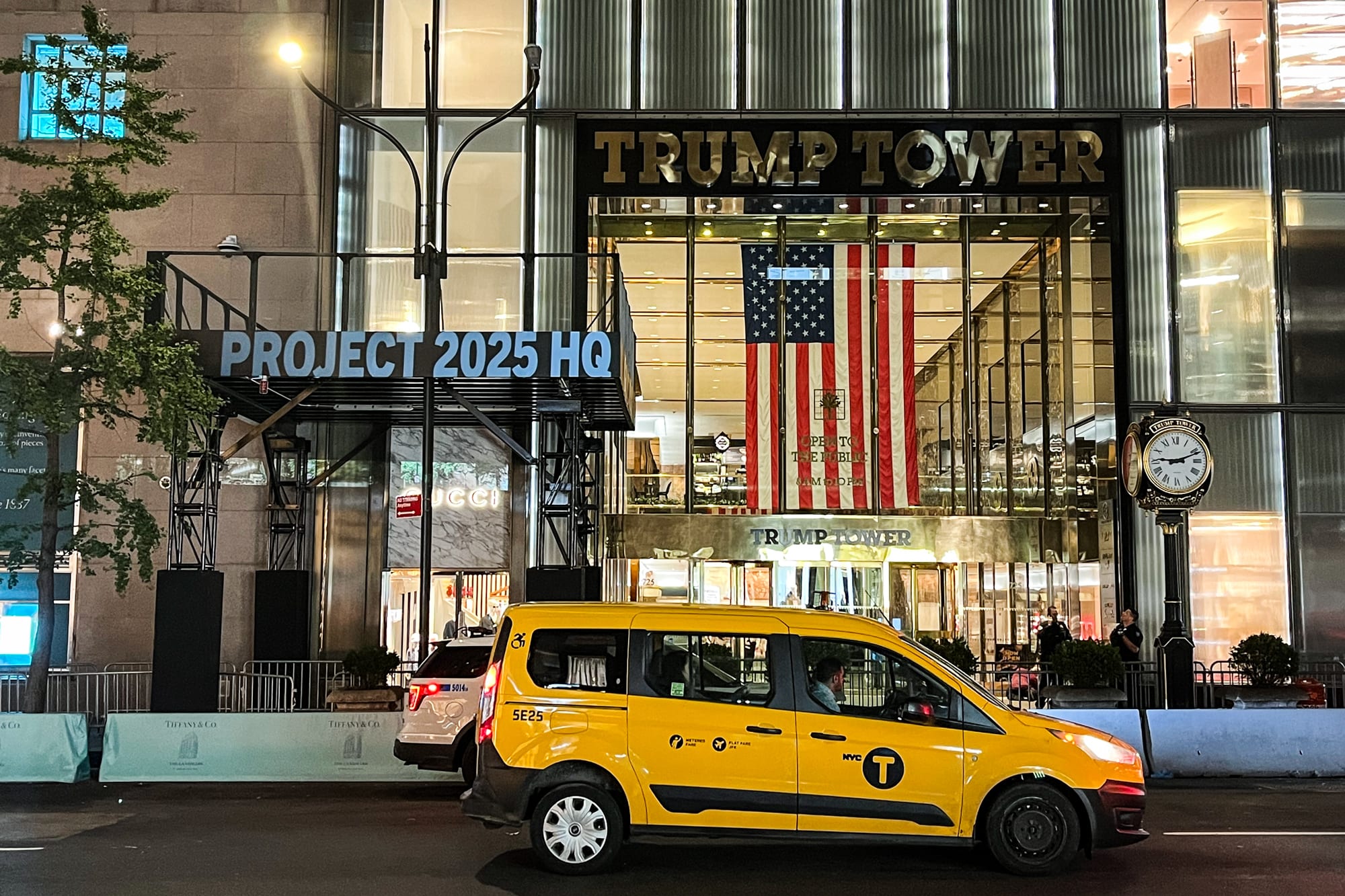 A projection reads "Project 2025 HQ" on the Trump Tower building