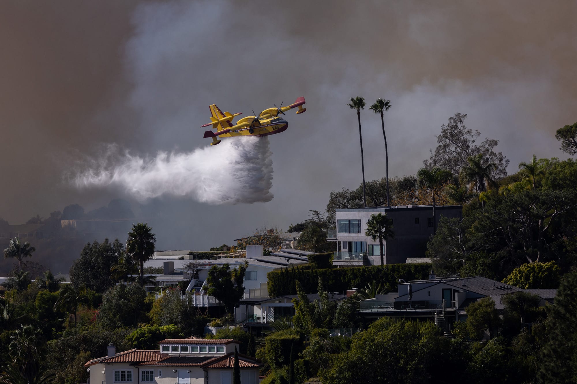 A Super Scooper drops ocean water on a hillside as the Palisades fire rages on Tuesday, Jan. 7, 2025 in Pacific Palisades, Calif.