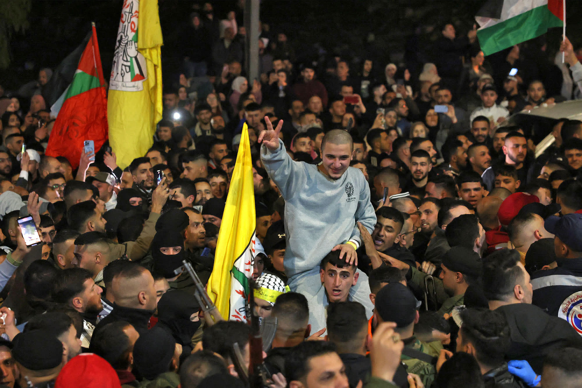 A crowd welcomes Palestinians formerly jailed by Israel as they arrive in a Red Cross convoy to Ramallah in the occupied West Bank on January 30, 2025. 