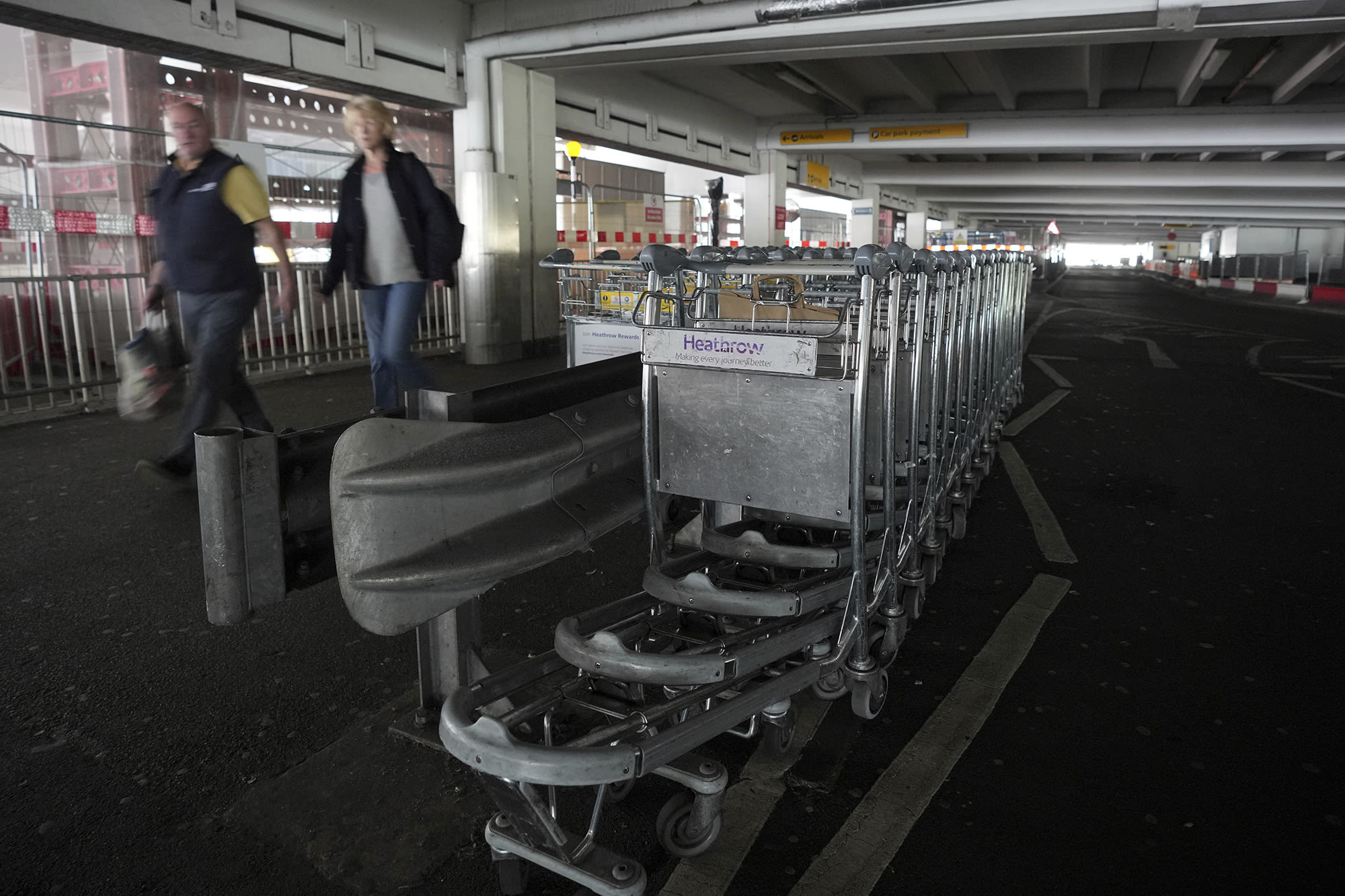 Travellers walk through the dark car park at Heathrow's Terminal 4 March 21, 2025.