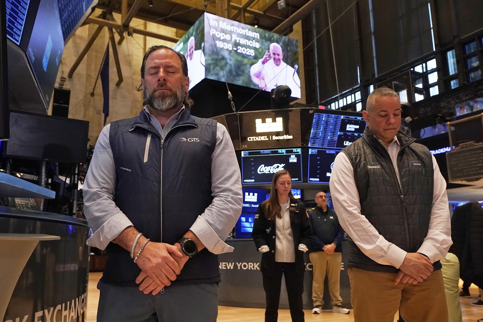 People on the floor of the New York Stock Exchange observe a moment of silence for Pope Francis on April 21, 2025.