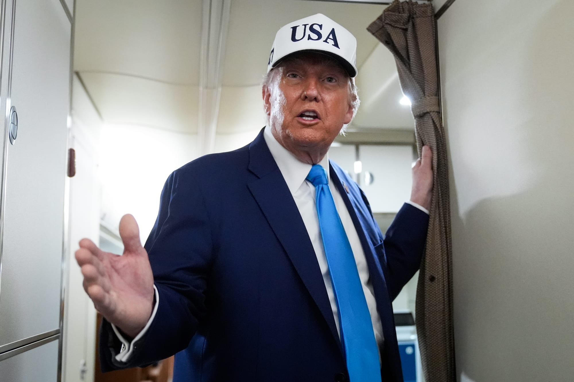 Donald Trump speaks while standing inside of a plane