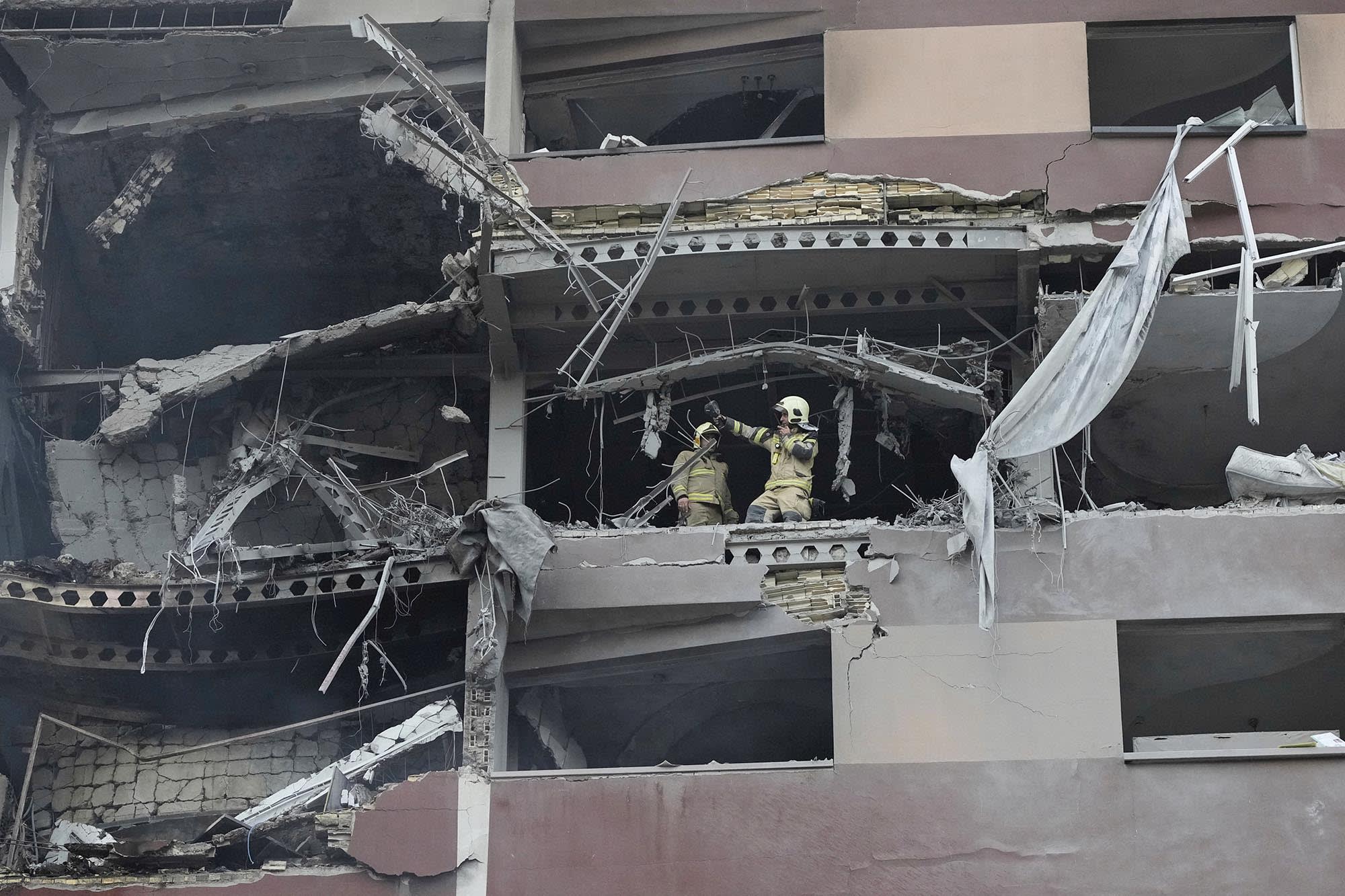 Firefighters work at the scene of an explosion at an apartment building in Tehran