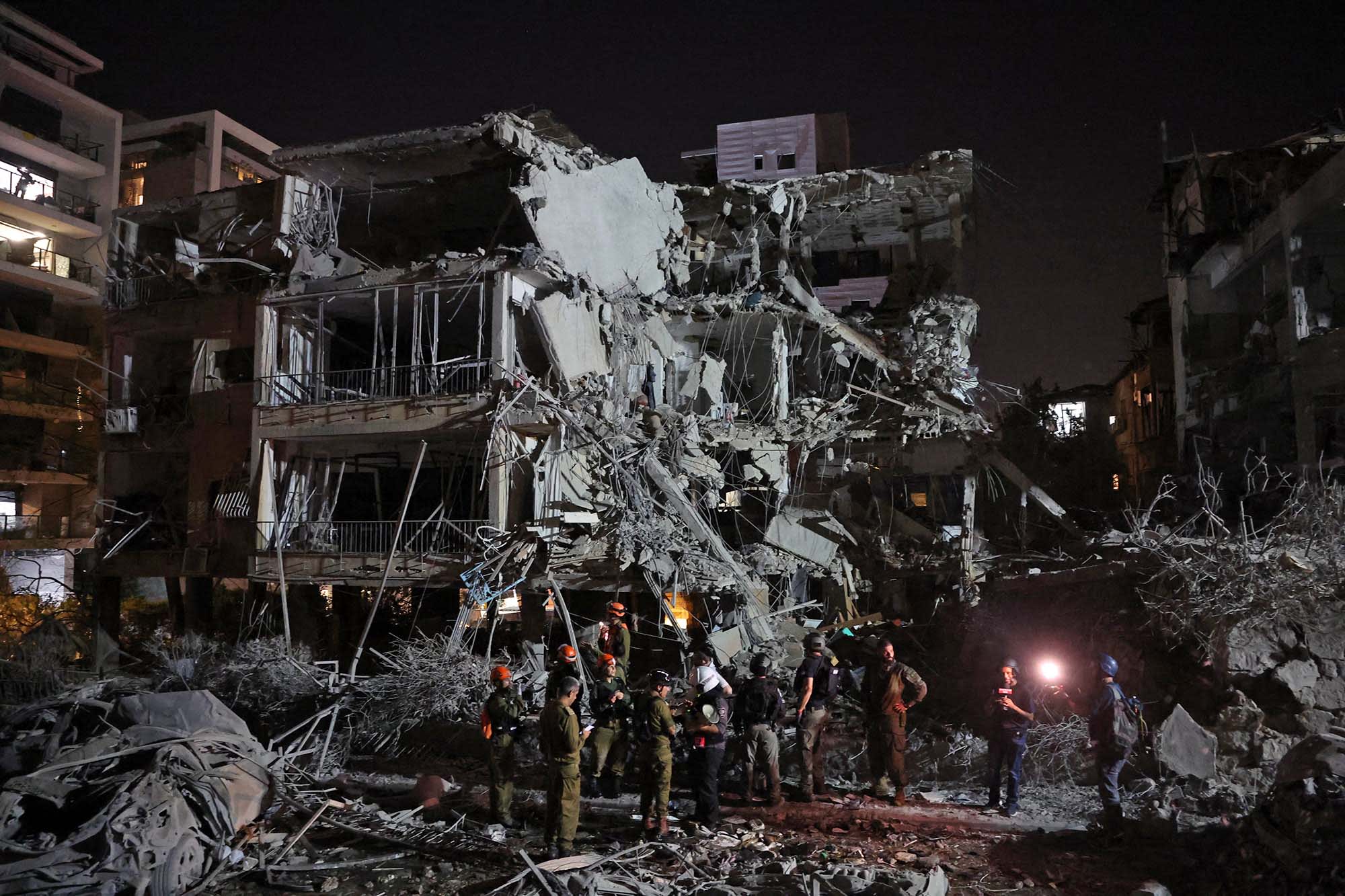 Israeli troops and first responders gather in front of a building hit by an Iranian missile in Tel Aviv on June 13, 2025.