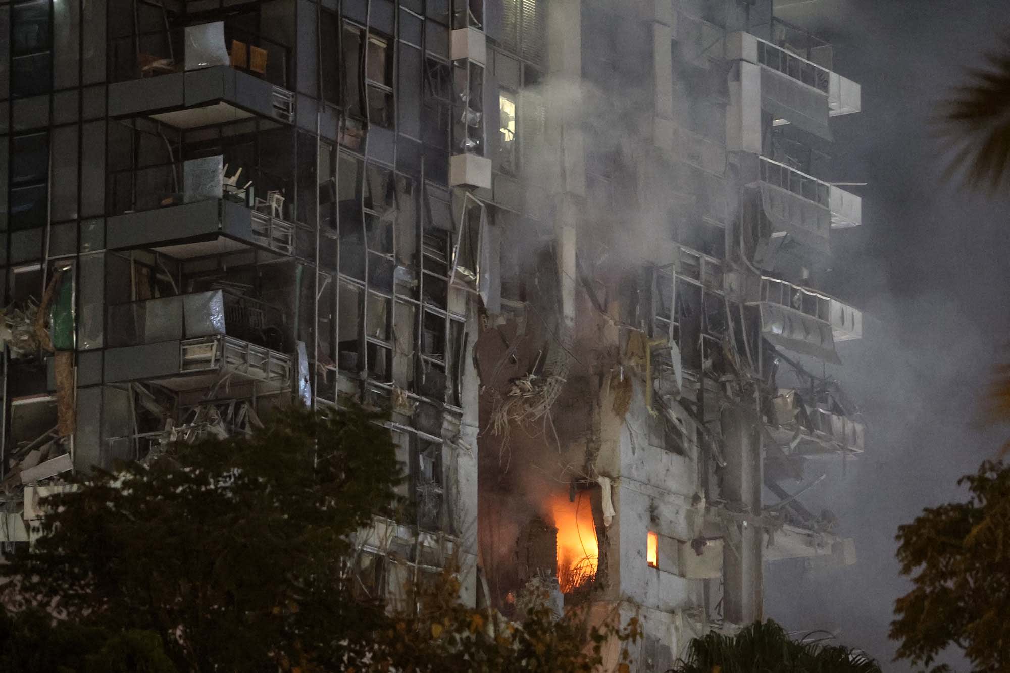 Fire and smoke rise from a building, reportedly hit by a missile fired from Iran, in central Tel Aviv on June 13, 2025.