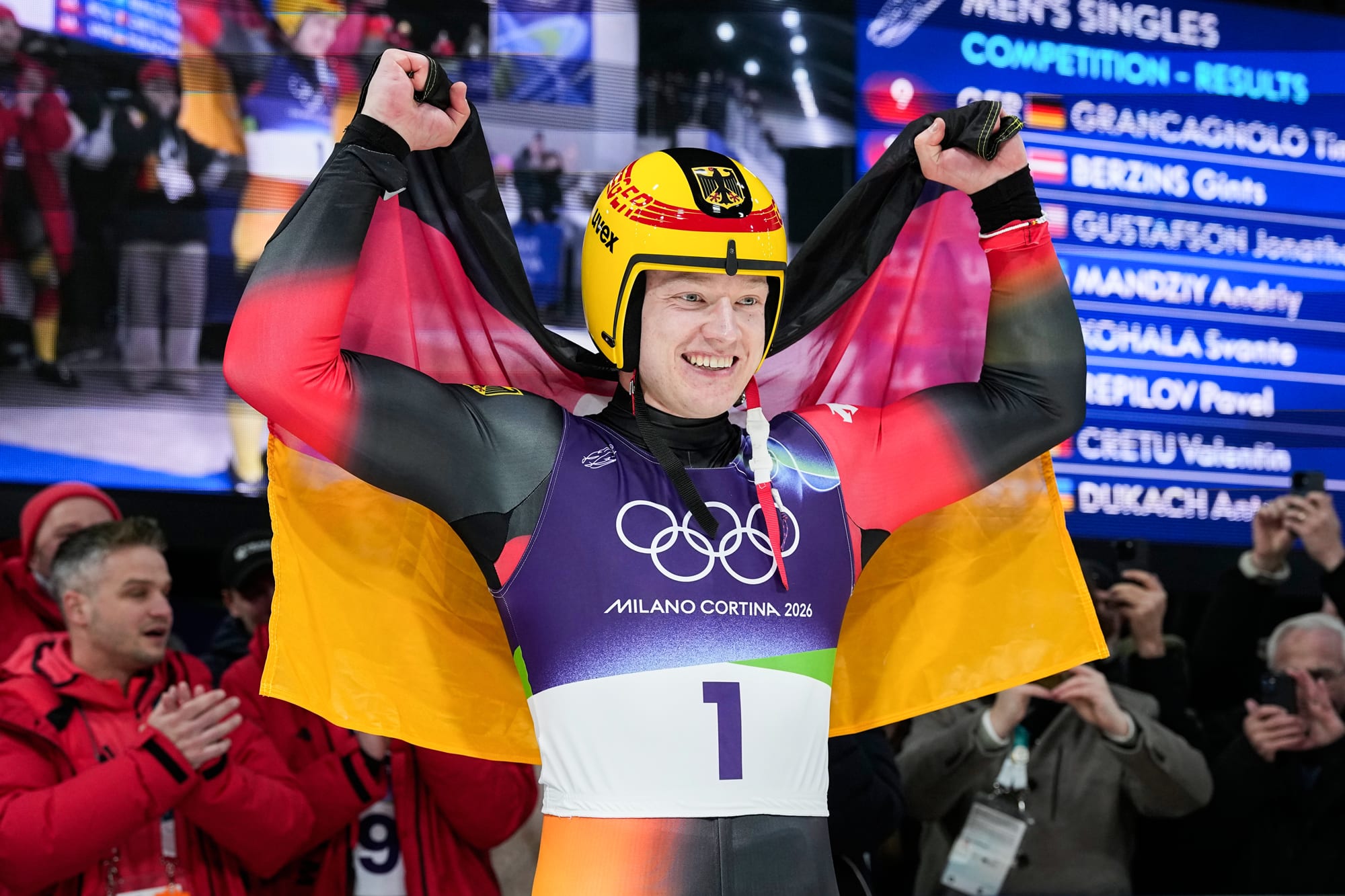 Max Langenhan holds a German flag behind his back and smiles
