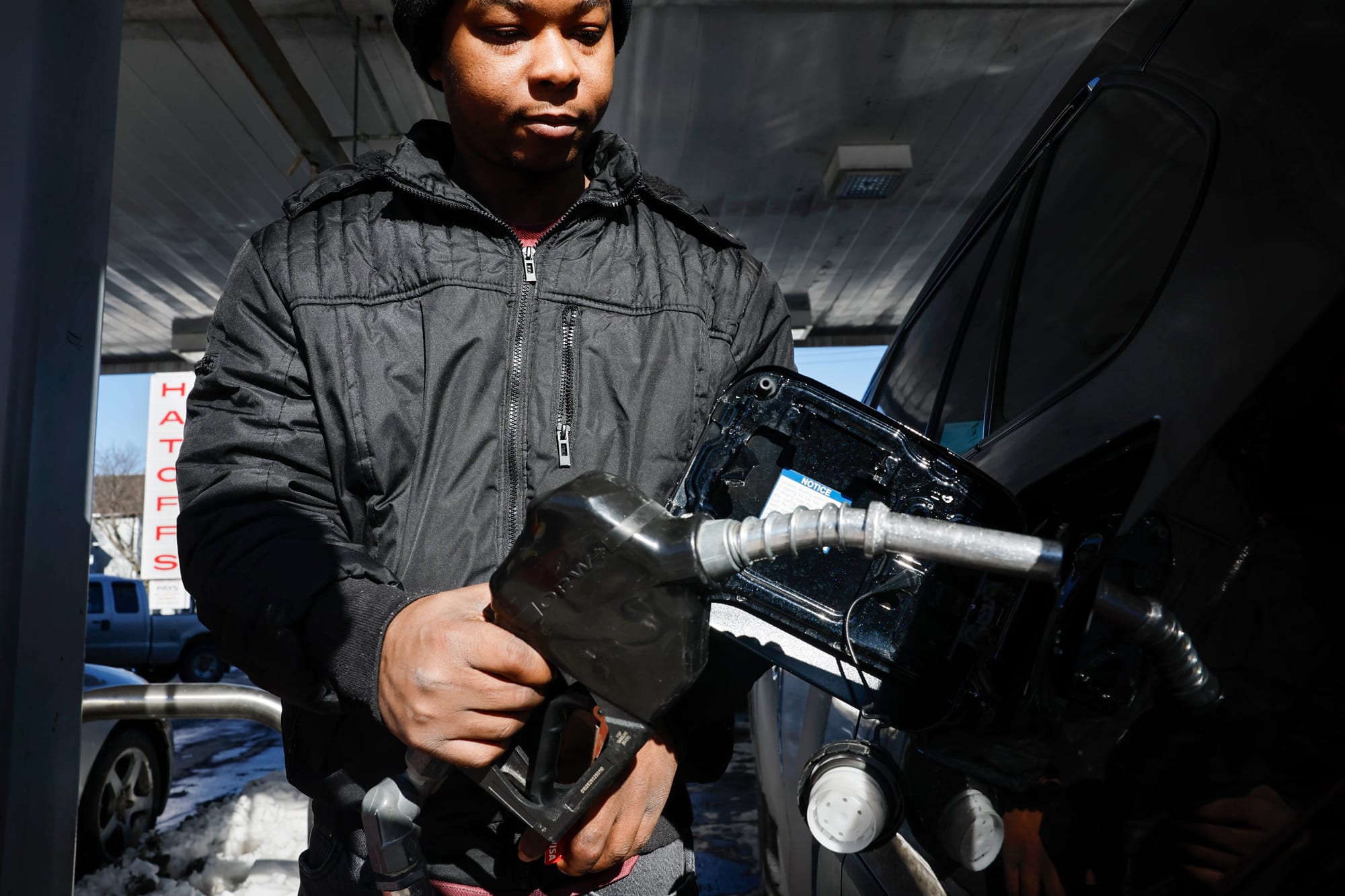 A person places a gas pump into their vehicle's gas chamber