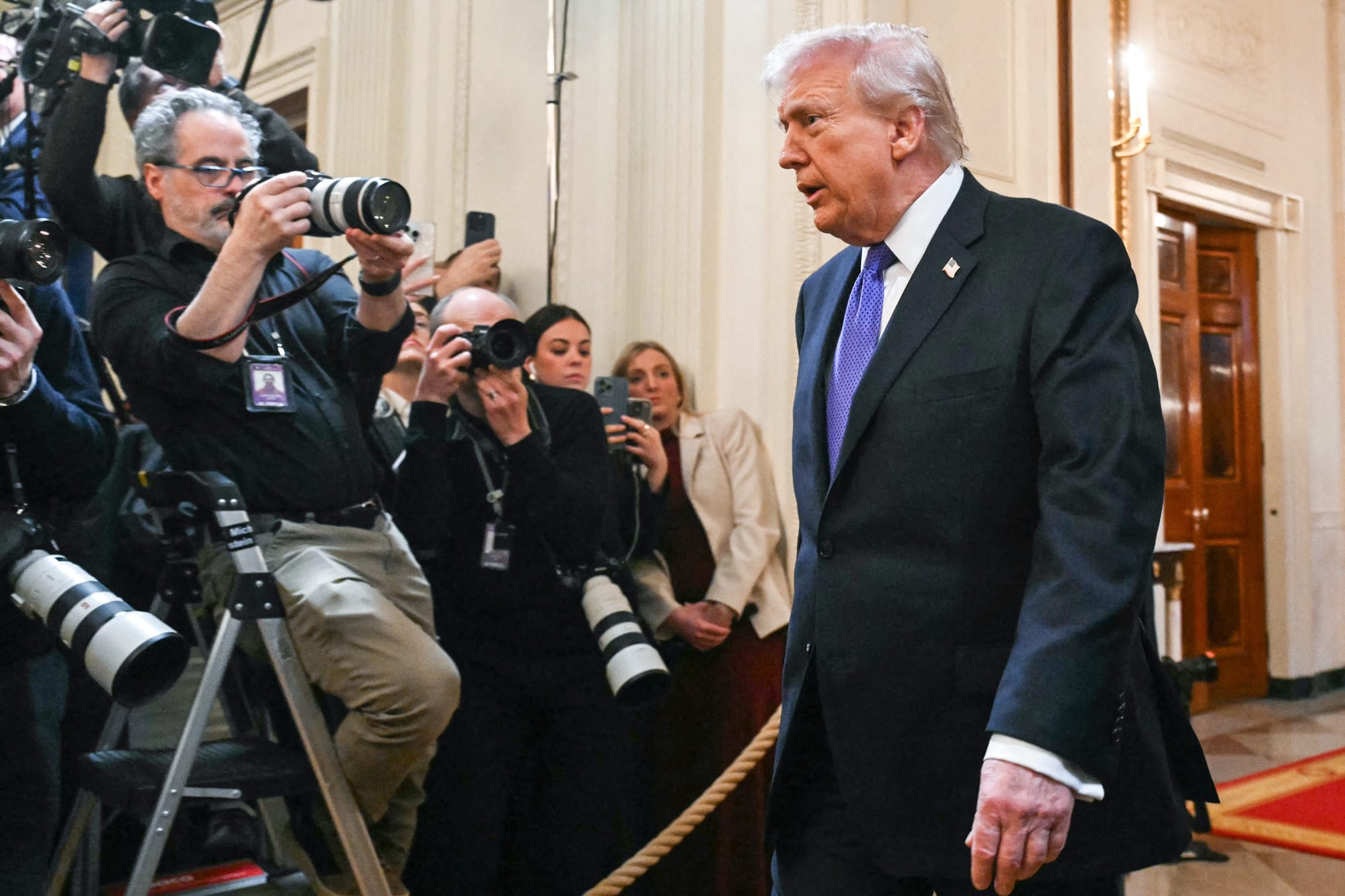 Donald Trump walks past a group of photographers and journalists