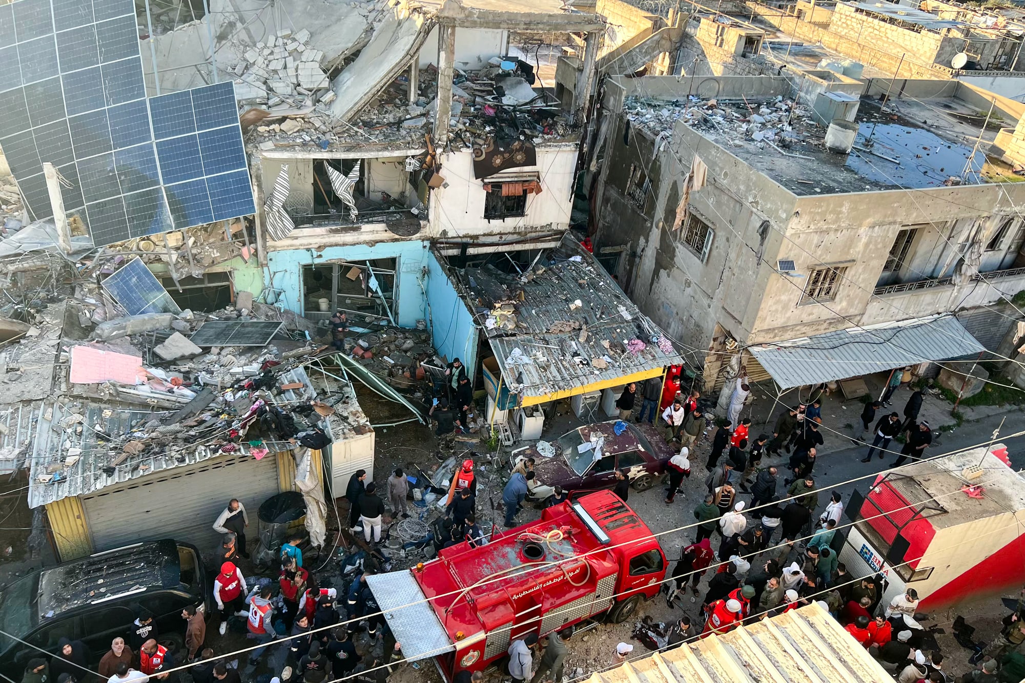 An aerial view of destroyed buildings as people walk on the street
