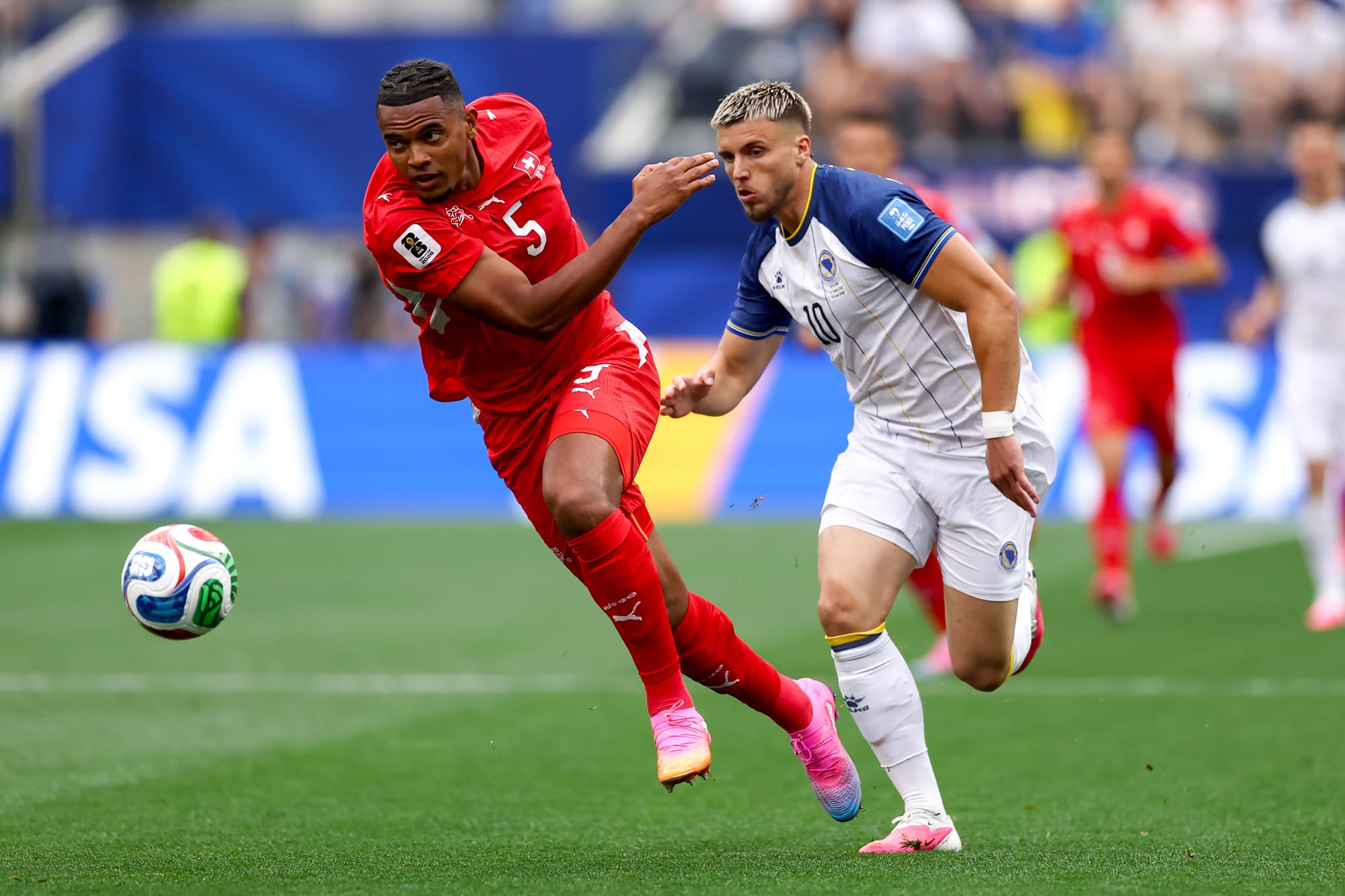Manuel Akanji chases after the ball under pressure from Ermedin Demirovic