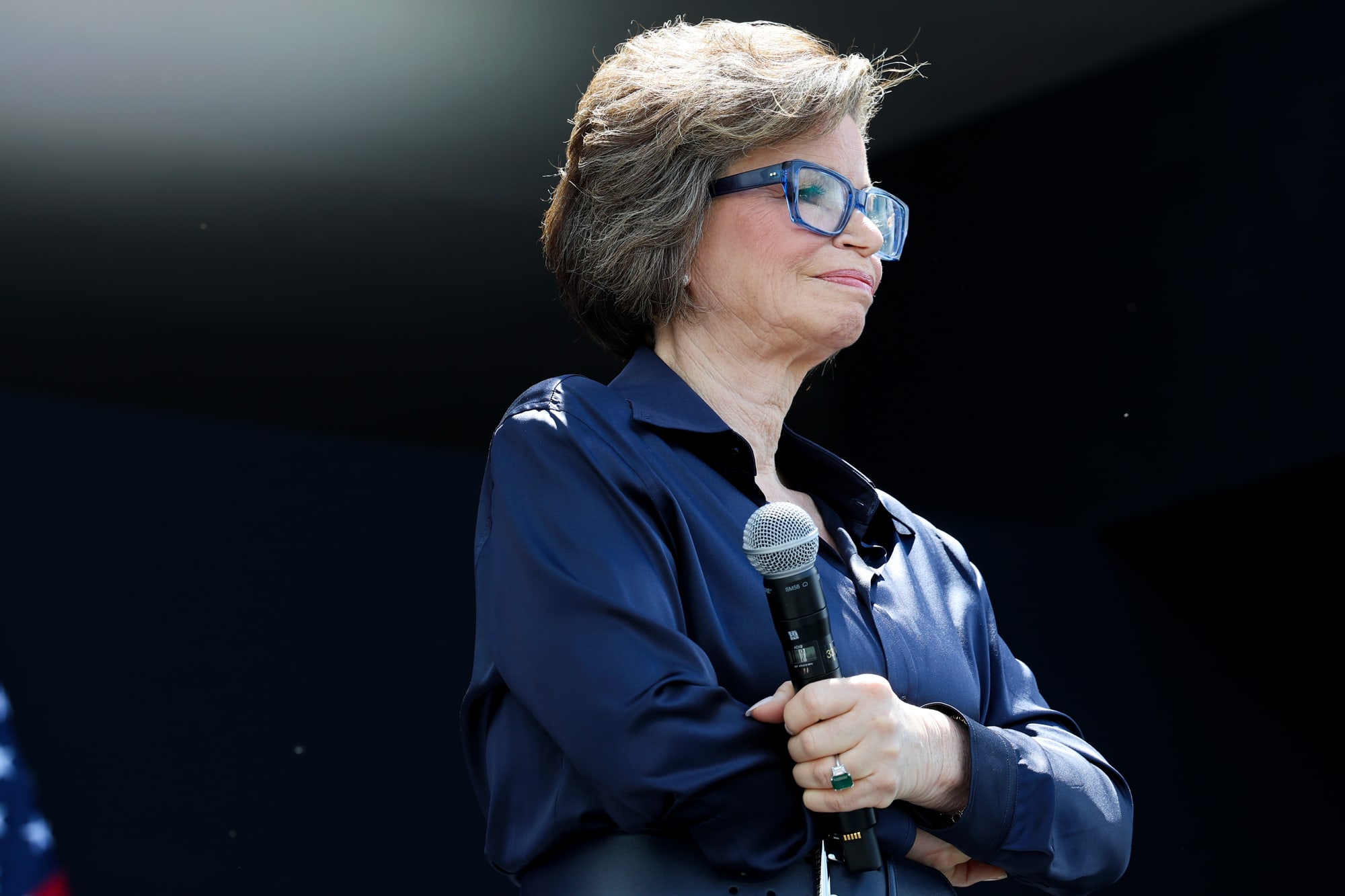Valerie Jarrett stands while holding a microphone